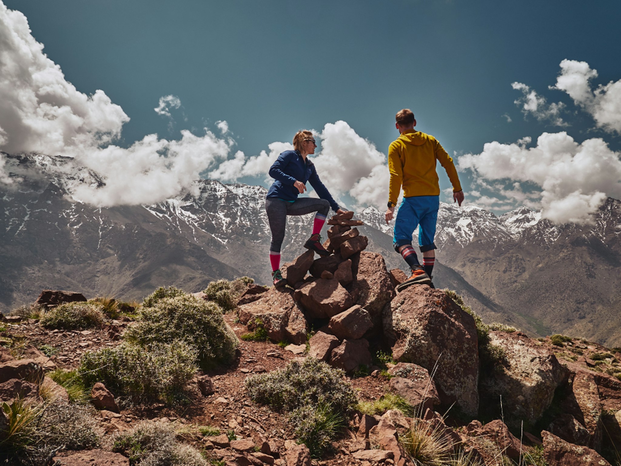 Young tourist couple watching spectacular mountain scenery of Jebel Toubkal range in High Atlas mountains Morocco, Africa