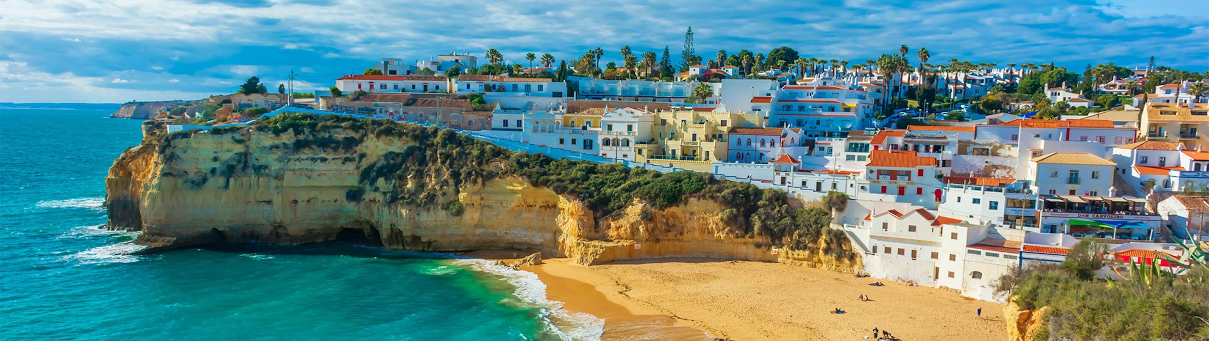 Golden beach, surrounded by cliffs with the clear sea in the Algarve region of Portugal