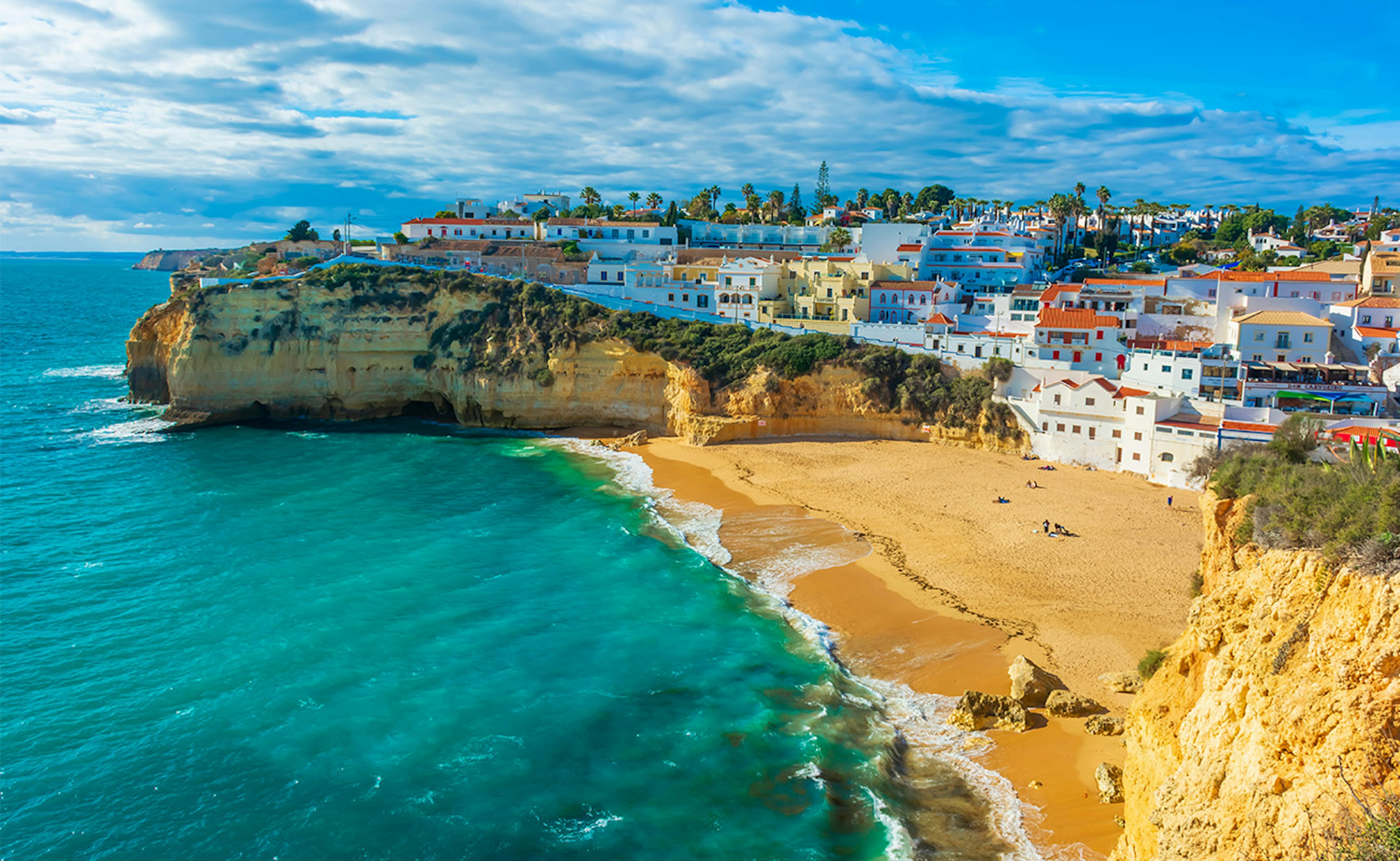 Golden beach, surrounded by cliffs with the clear sea in the Algarve region of Portugal