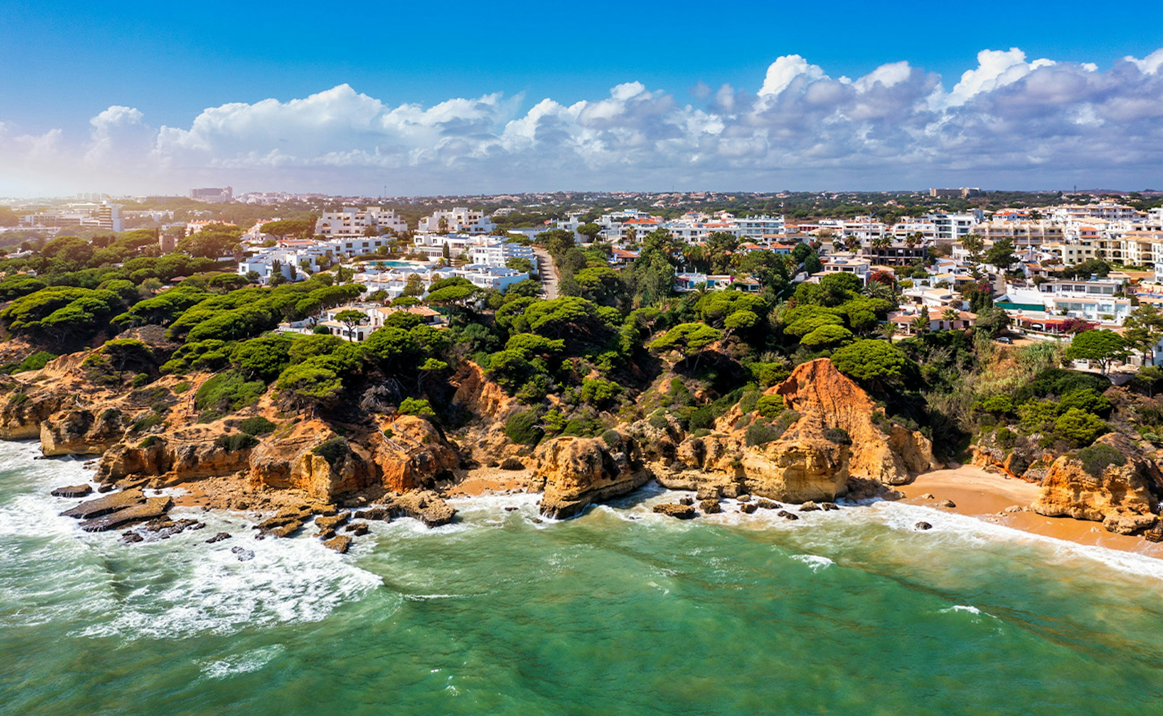 Klettar, sjór og falleg borgin Albufeira í Portúgal