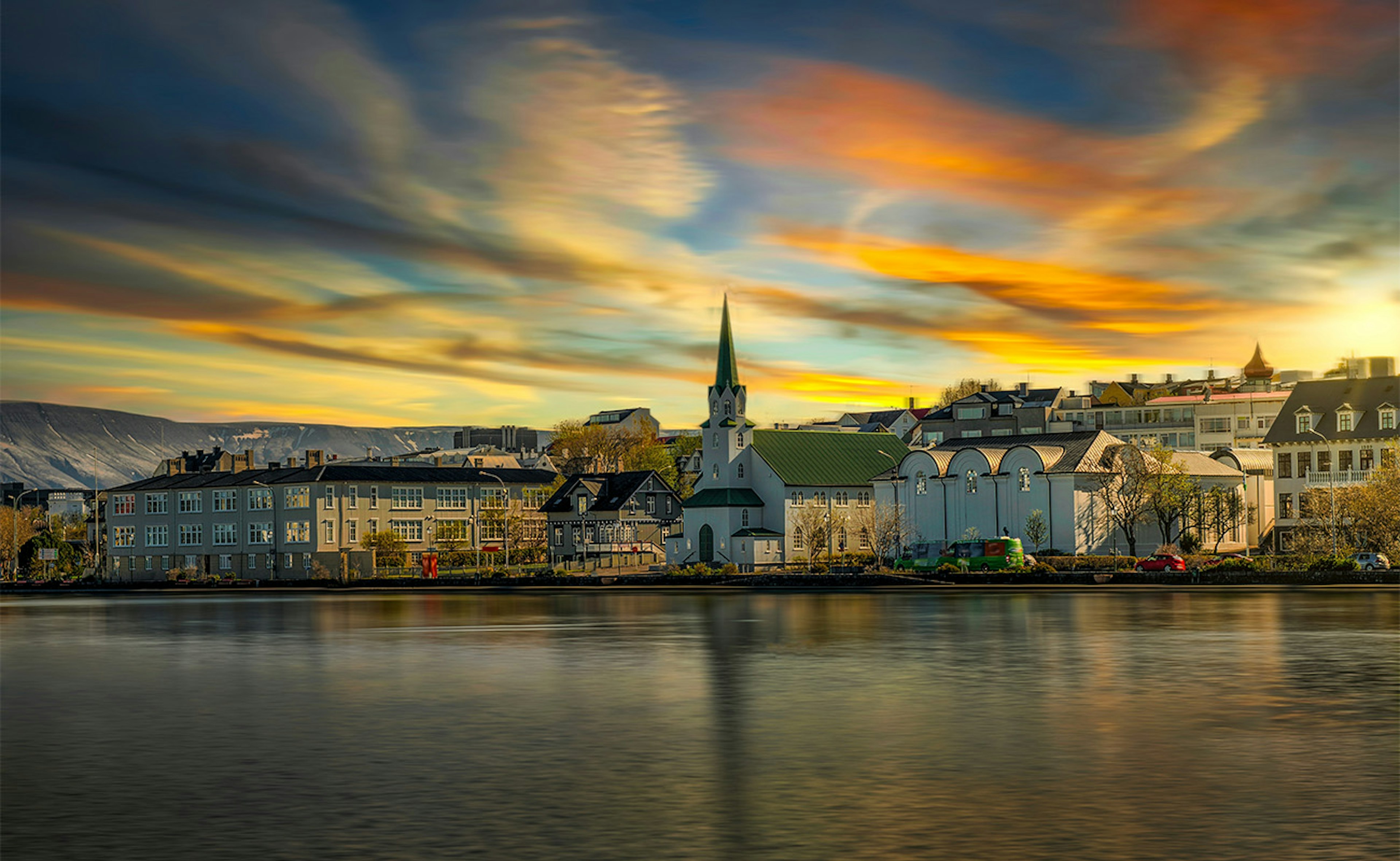 Dawn in downtown Reykjavik with colorful skies above the city pond