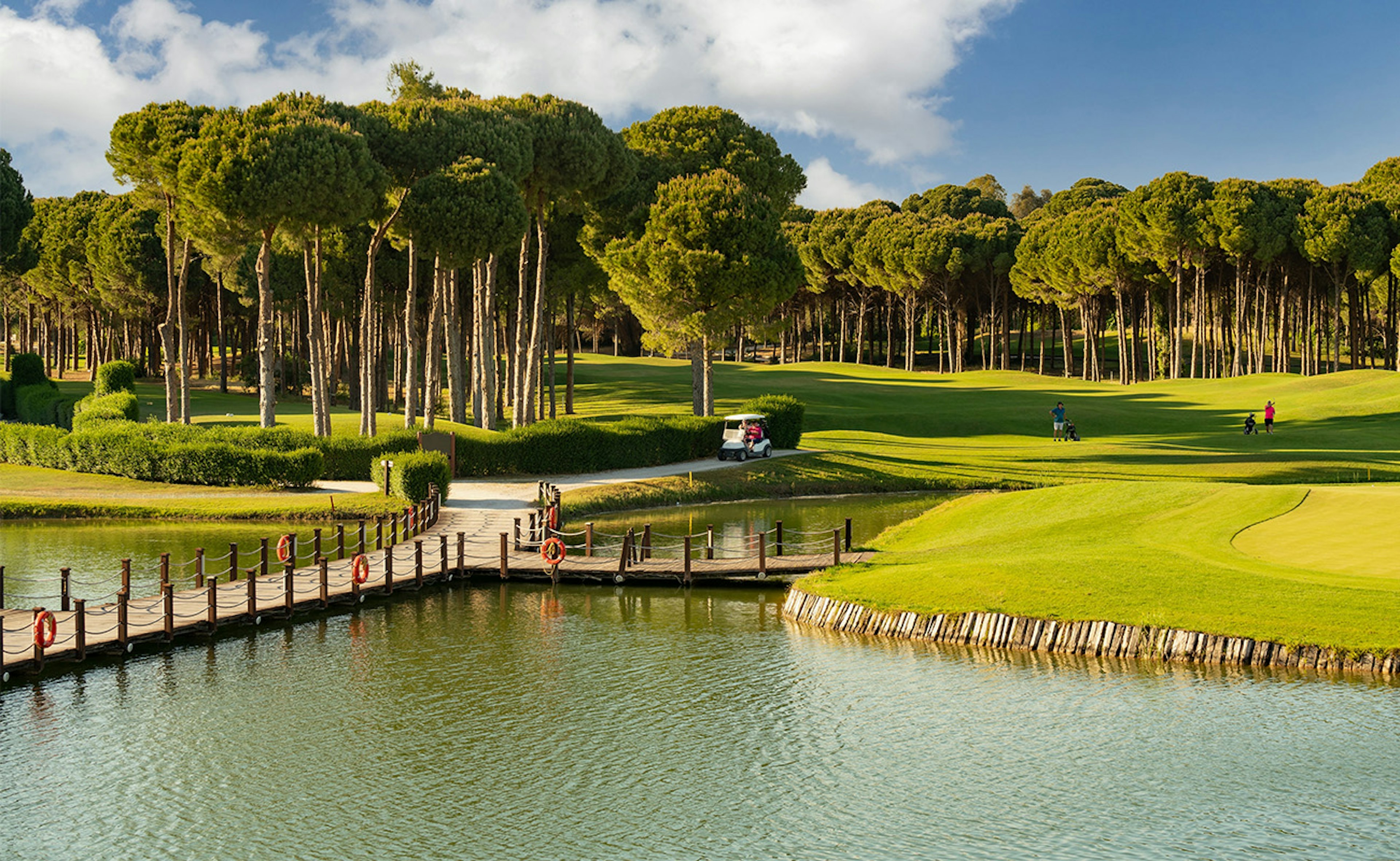 Golf course in Belek, Turkey with lake, golf cart and players.