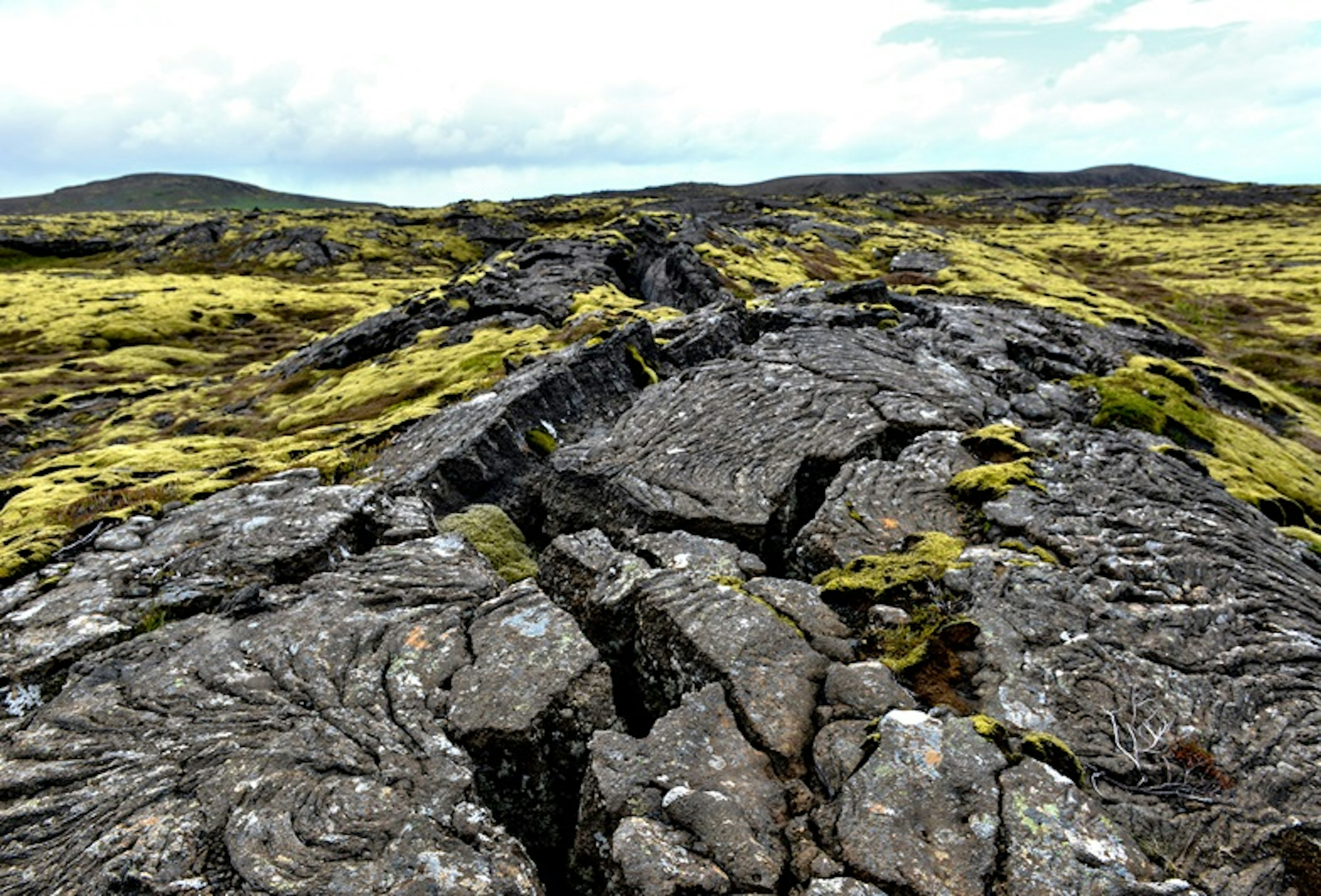 An old lava field in Iceland with a crack in the middle