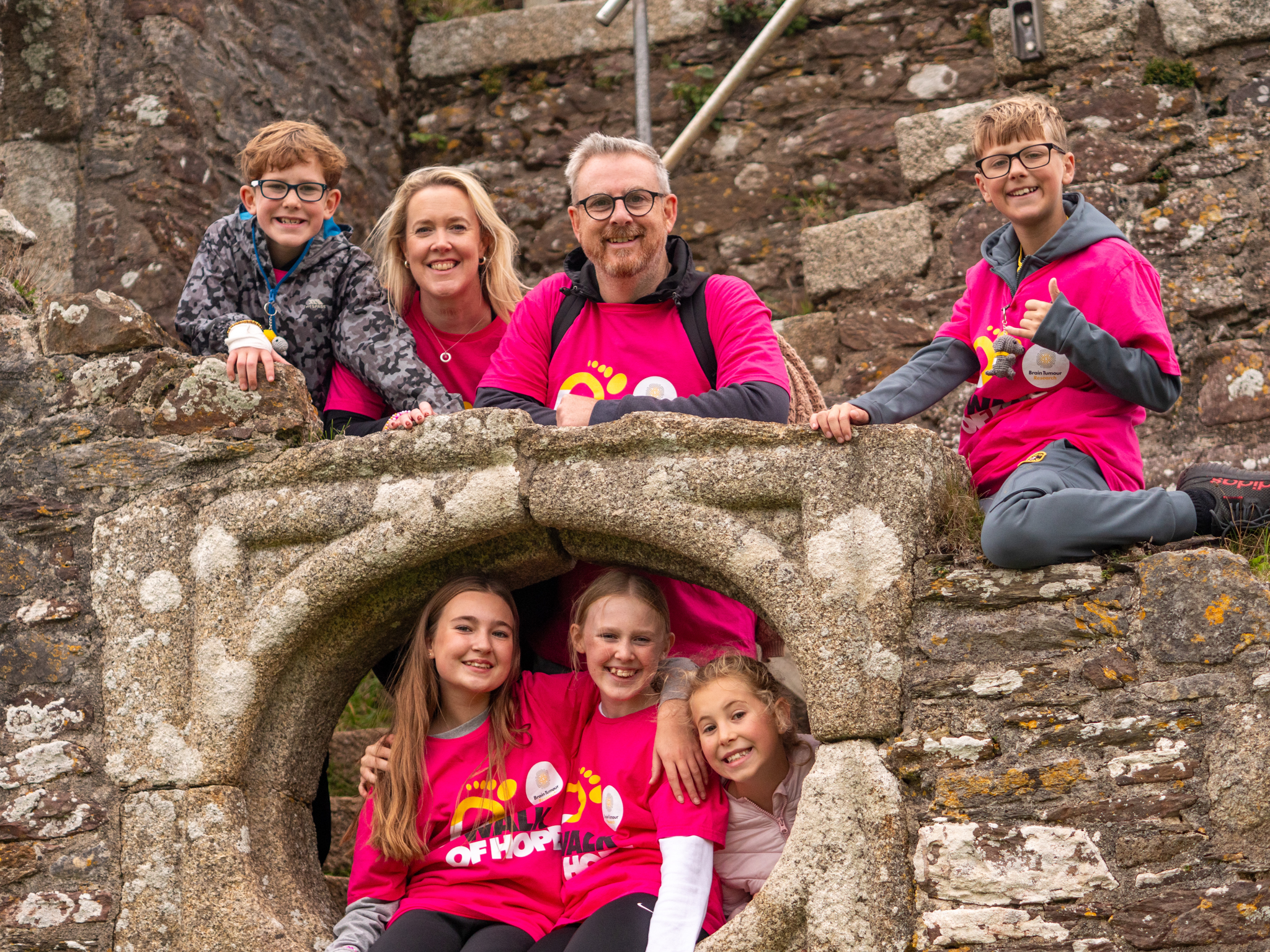 Family wearing Walk of Hope t-shirts smiling in front of a historical landmark. 