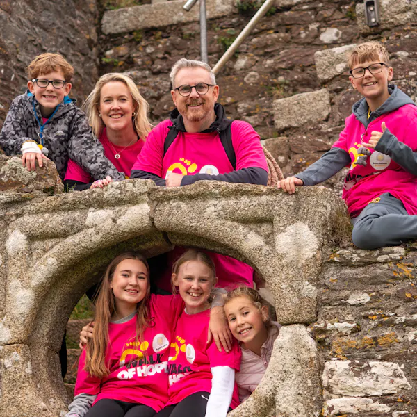Family wearing Walk of Hope t-shirts smiling in front of a historical landmark.