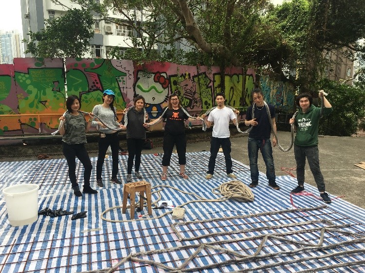 Seven People holding a thick rope