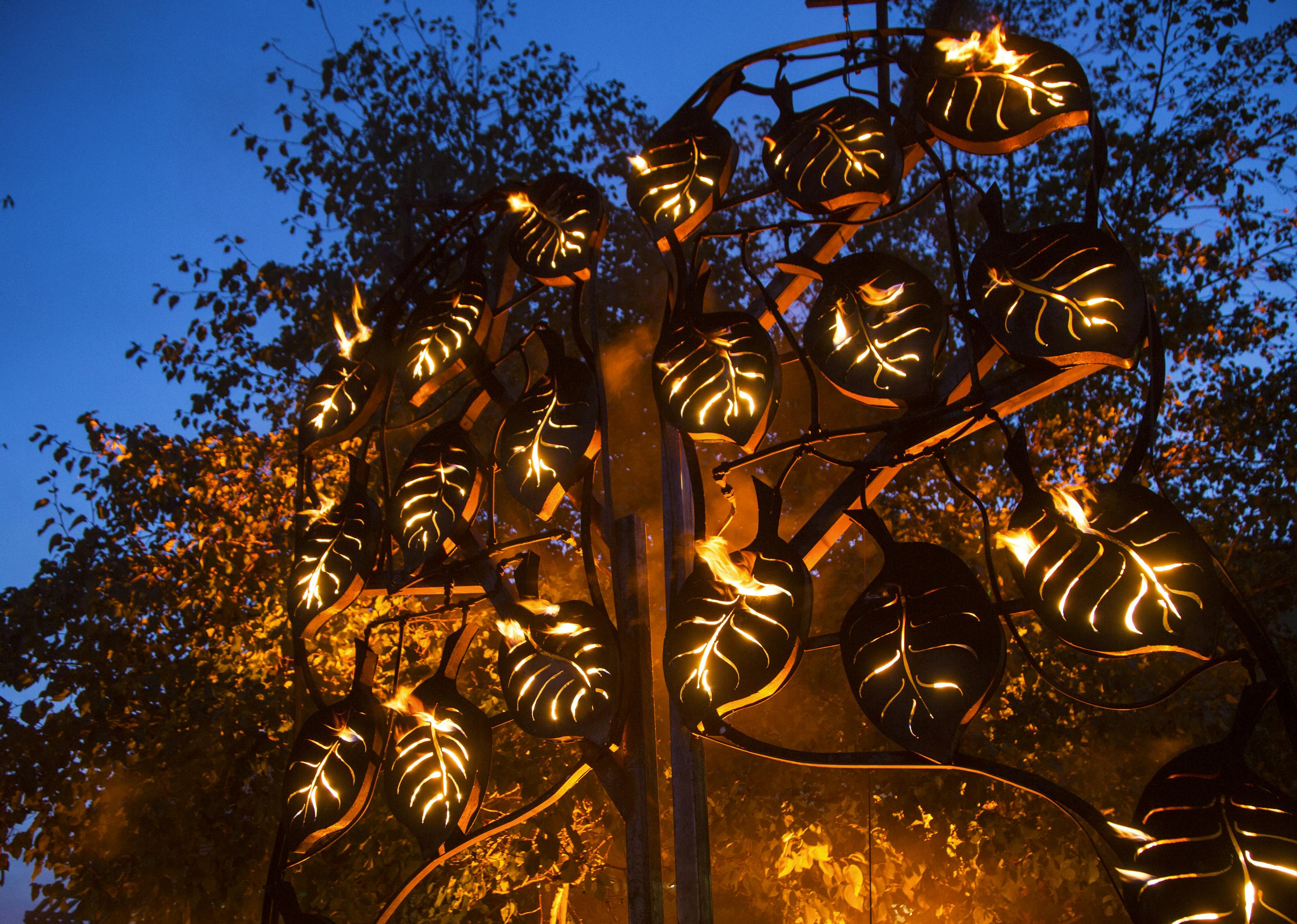 A metal tree illuminated from the inside with fire