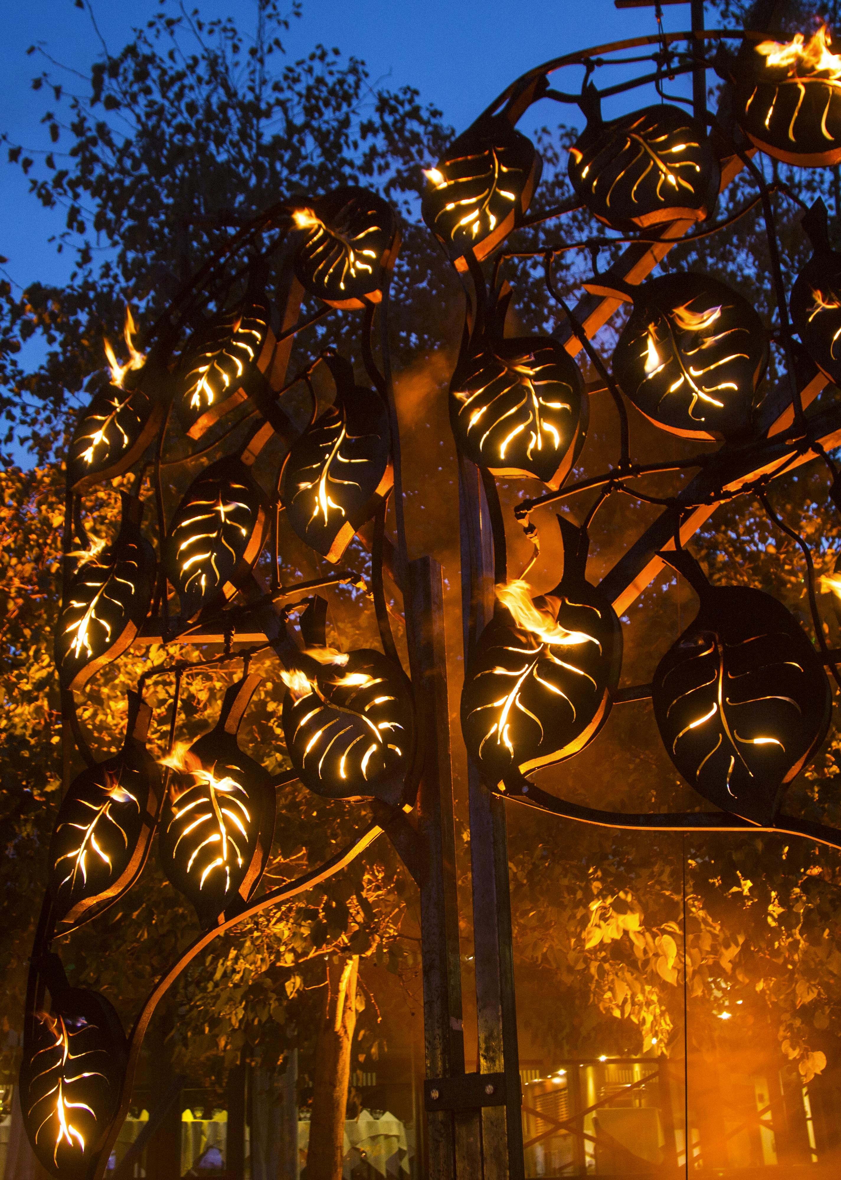 A metal tree illuminated from the inside with fire