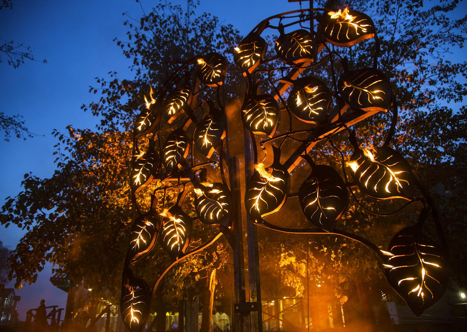 A metal tree illuminated from the inside with fire