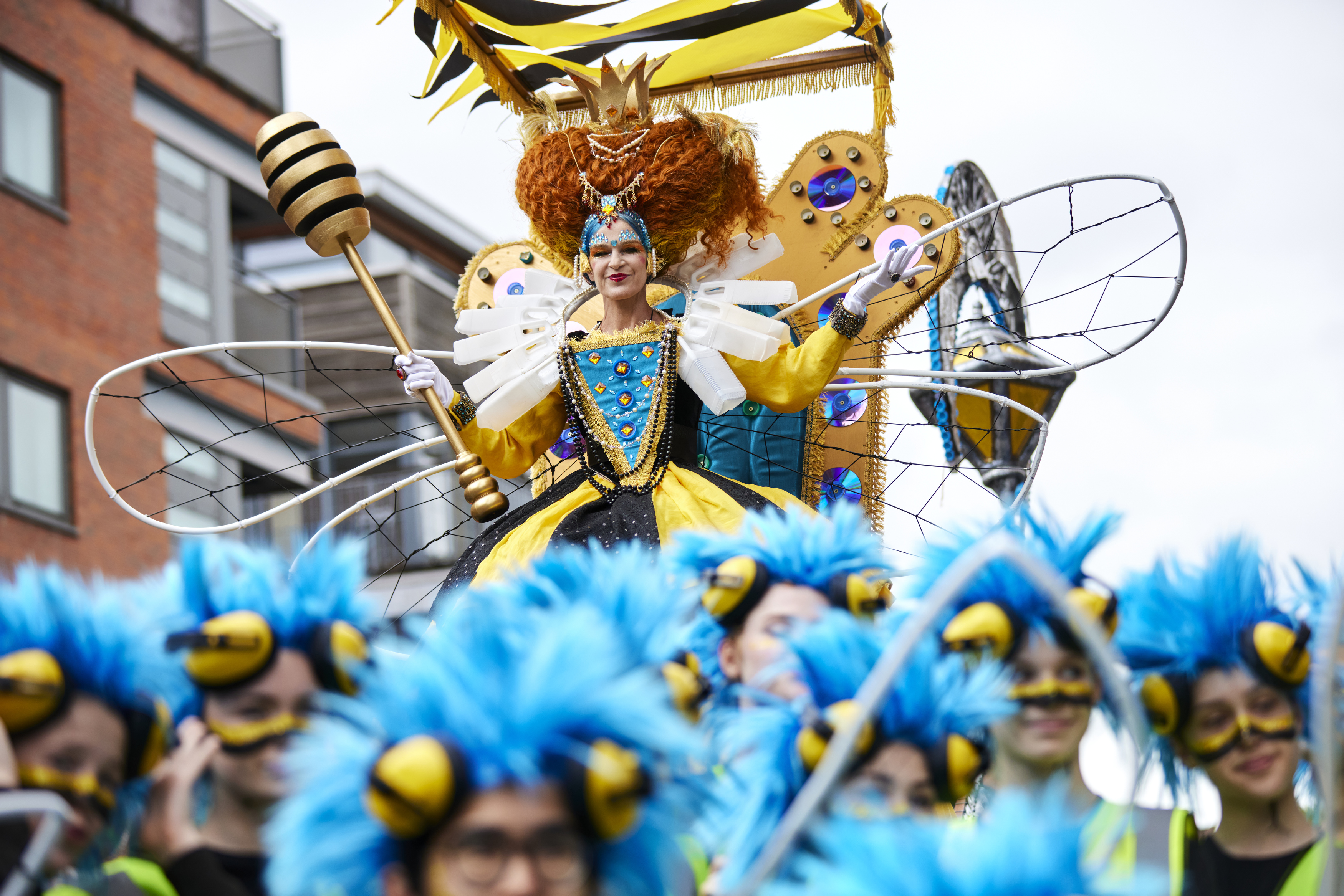 A person dressed up as a bee queen on a float