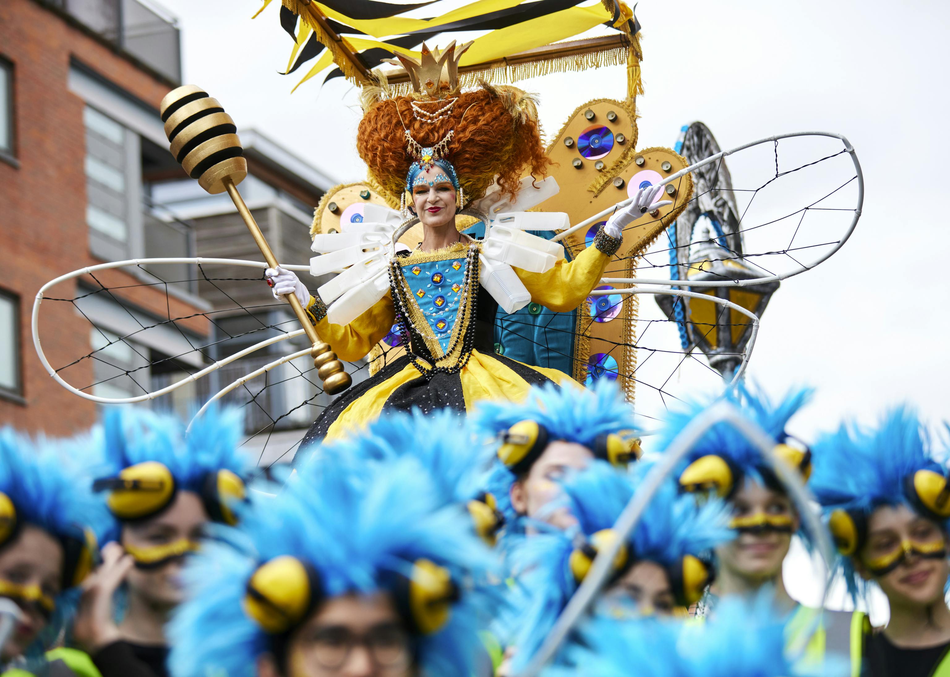 A person dressed up as a bee queen on a float