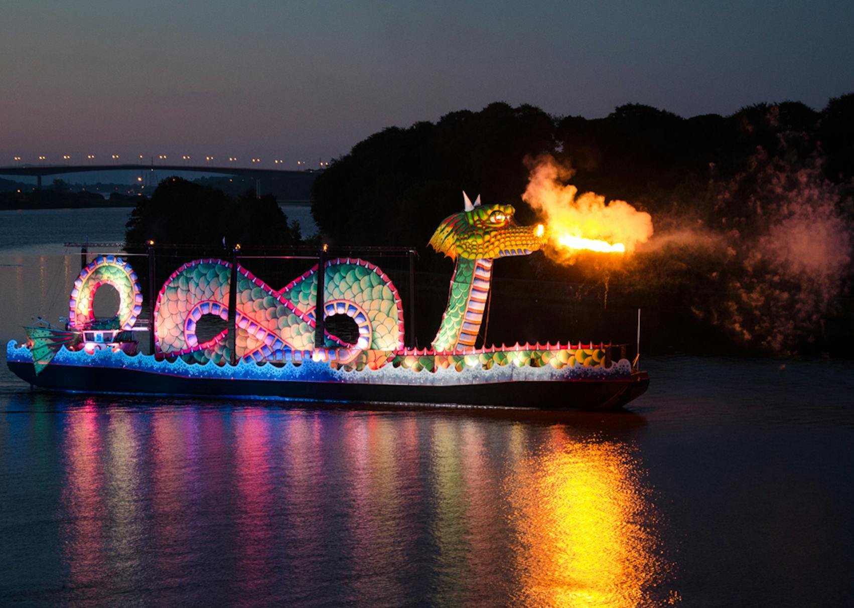 A large green dragon atop a boat breathing fire 