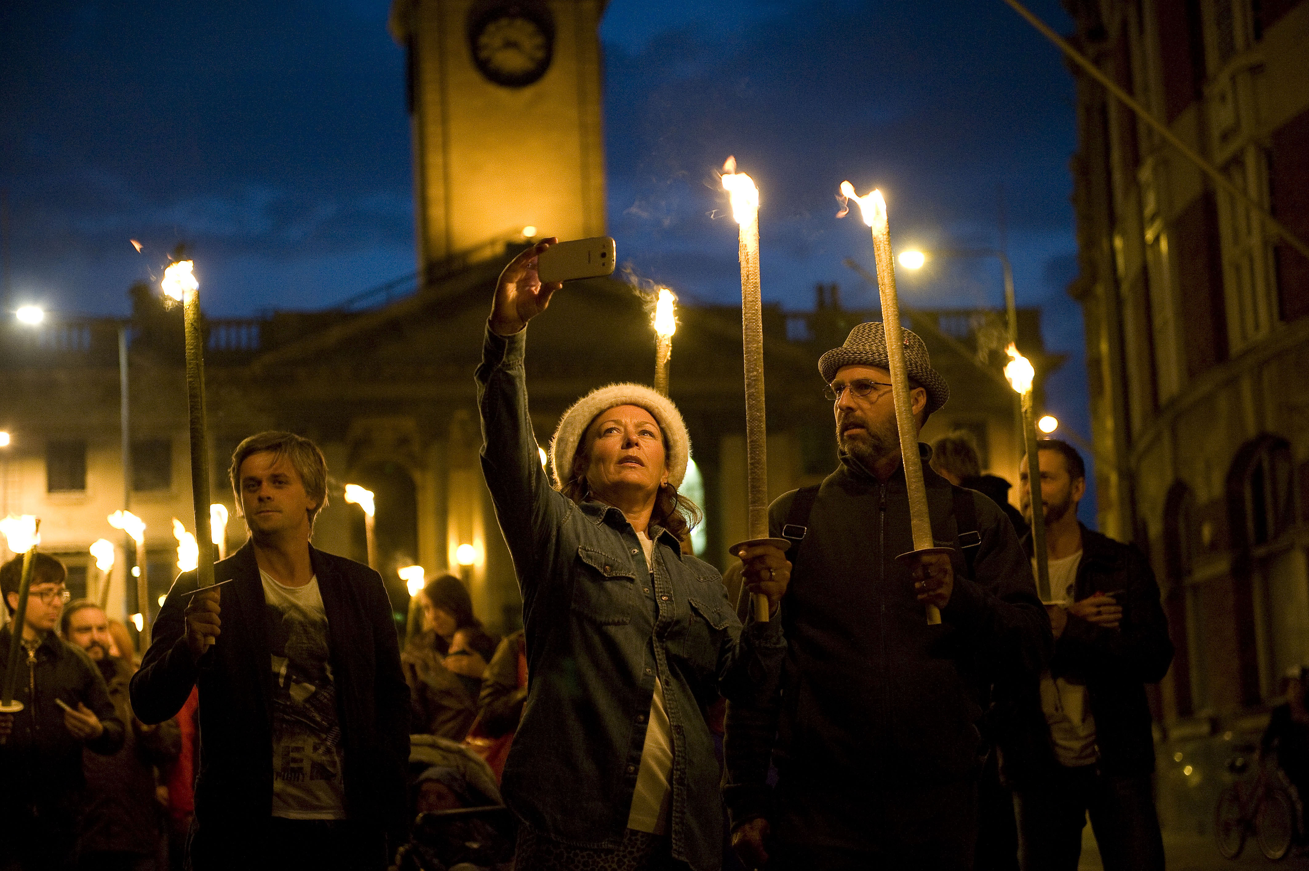 A procession of people carrying torches