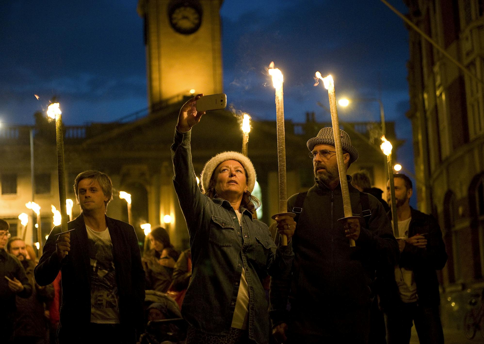 A procession of people carrying torches