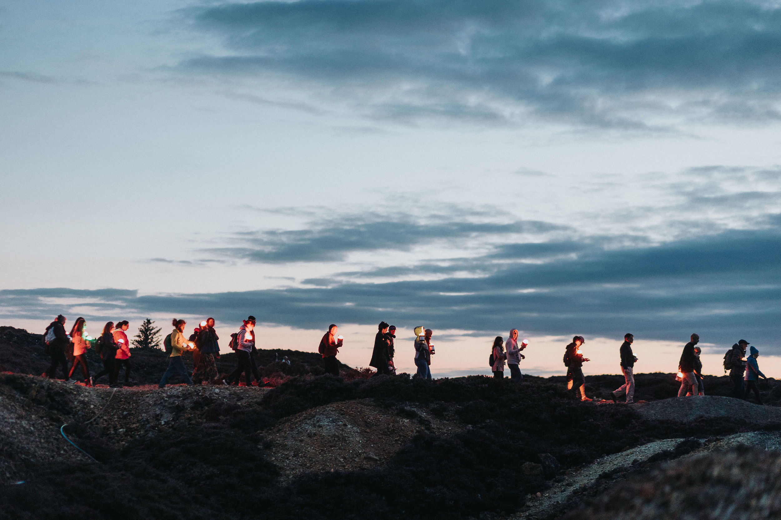 Lumenators holding their geolights walking in the landscape