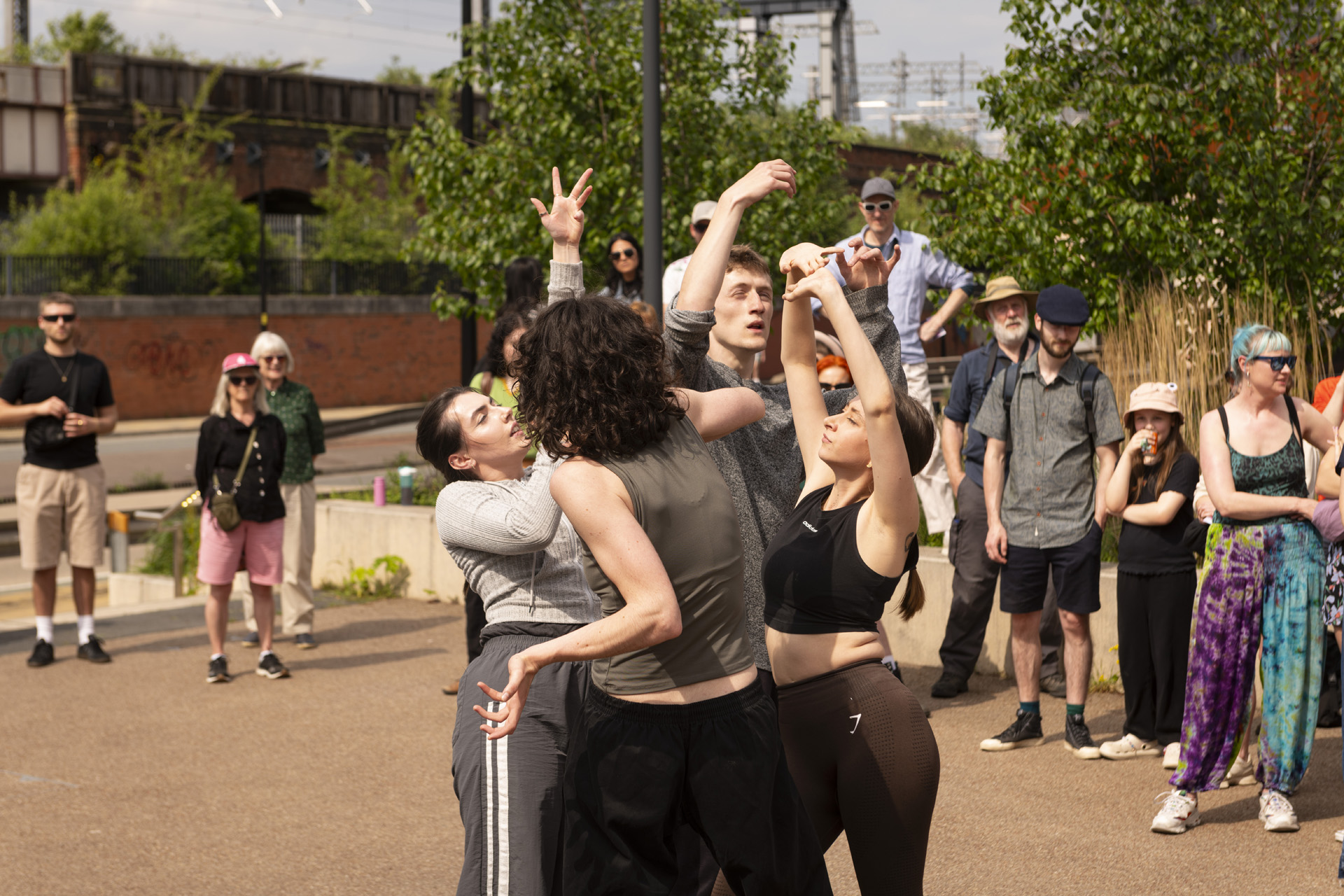 A group of dancers dancing in the street surrounded by audiences