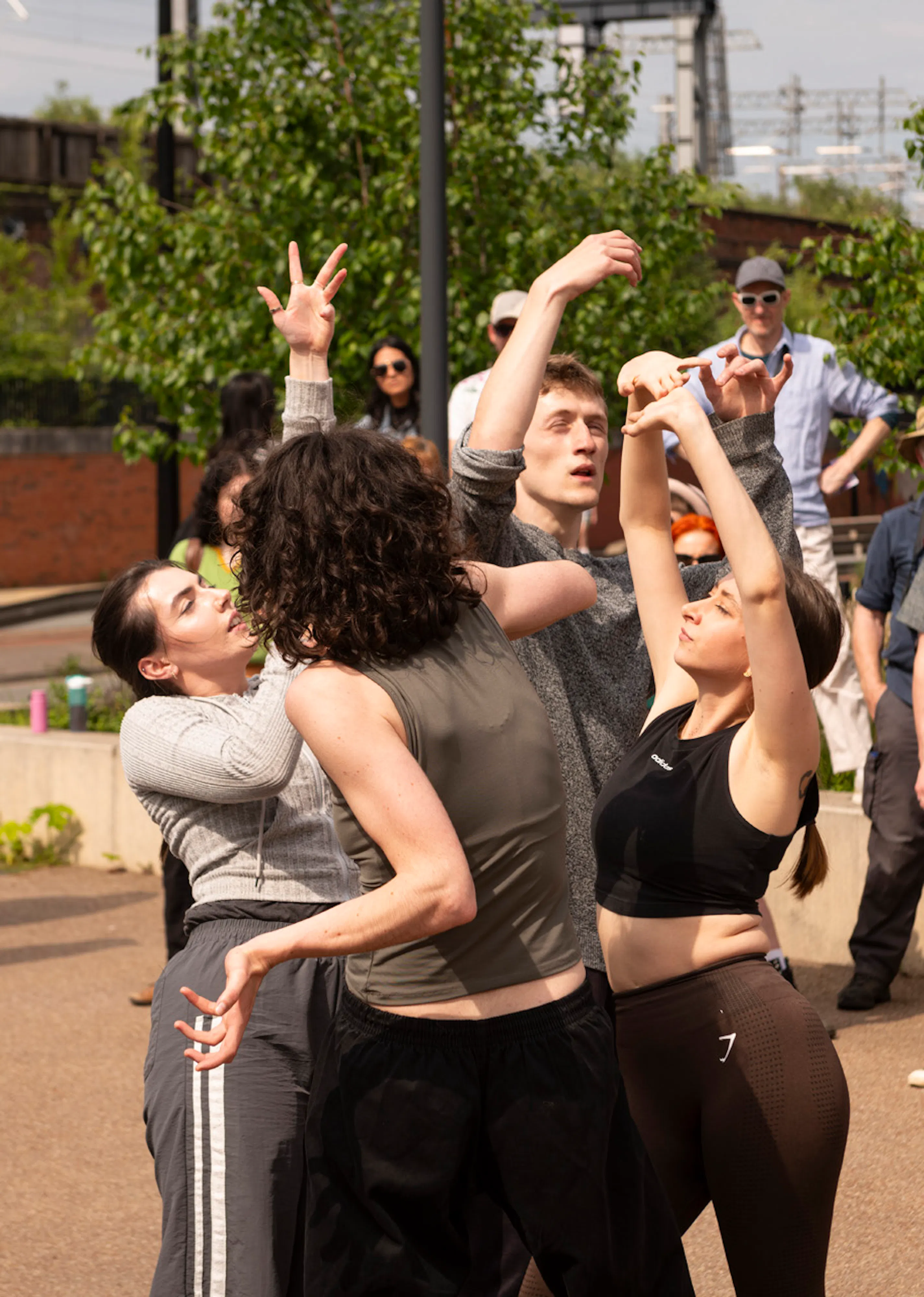 A group of dancers dancing in the street surrounded by audiences