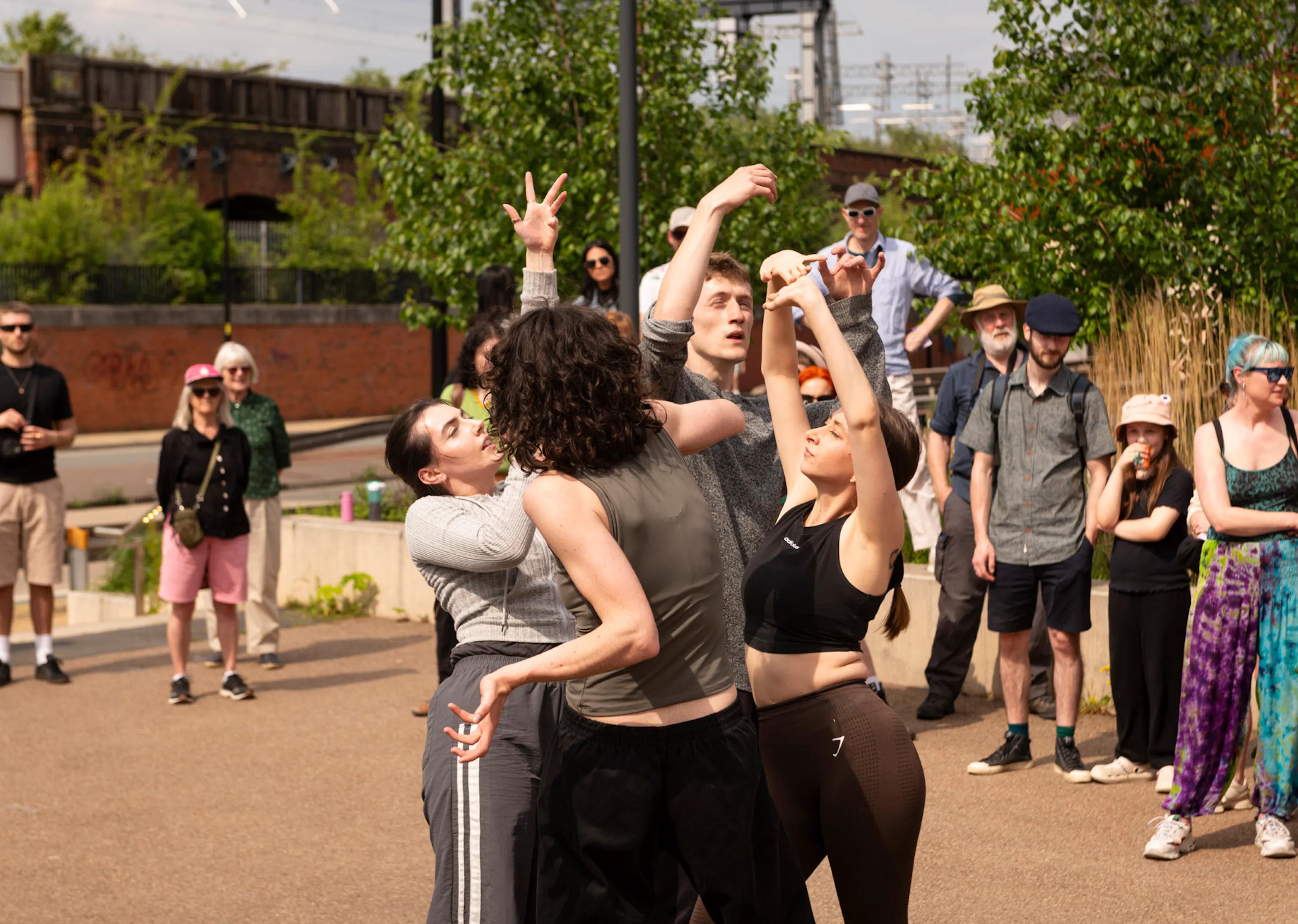 A group of dancers dancing in the street surrounded by audiences