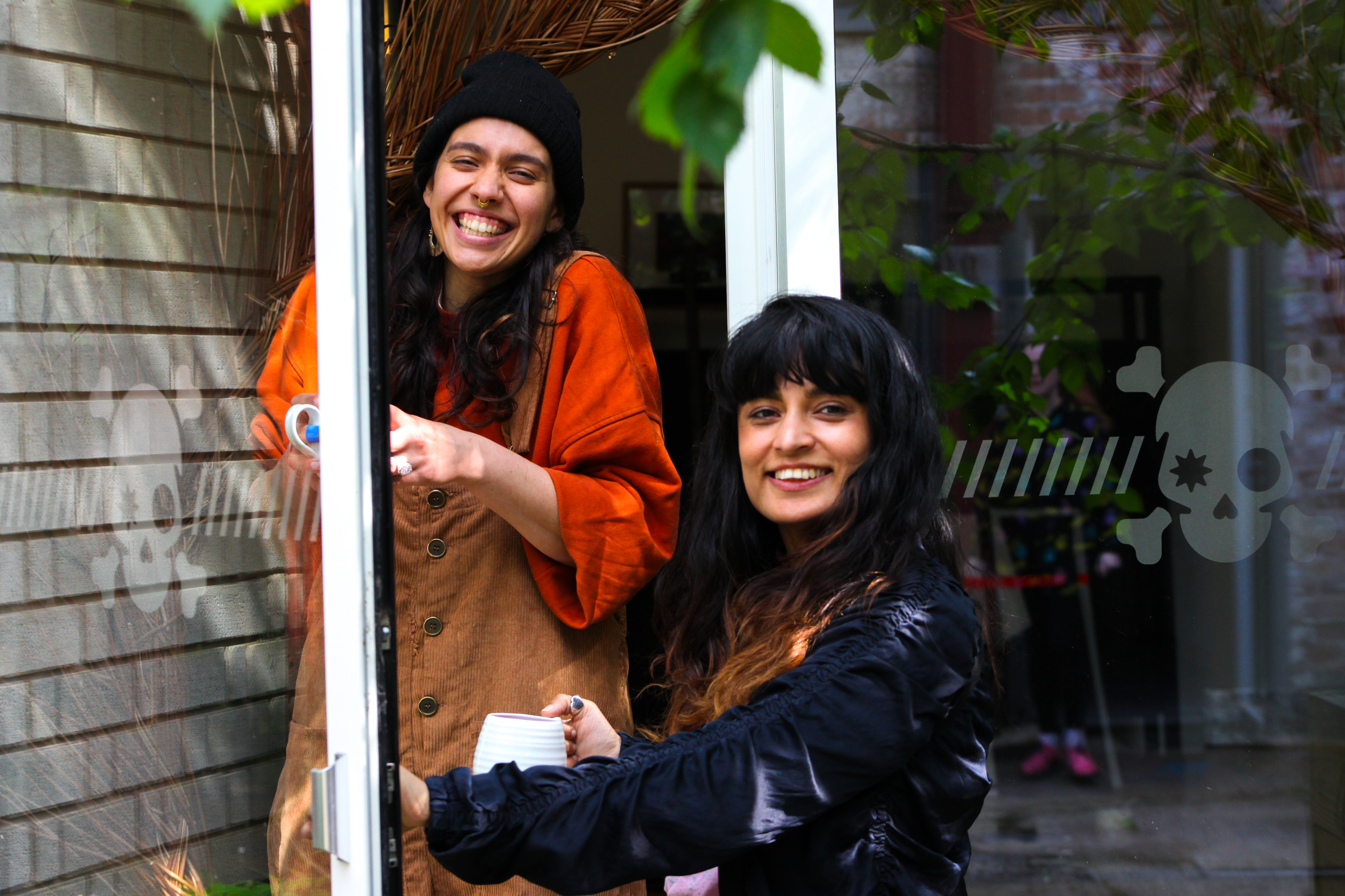 Two people smiling with tea cups in their hands