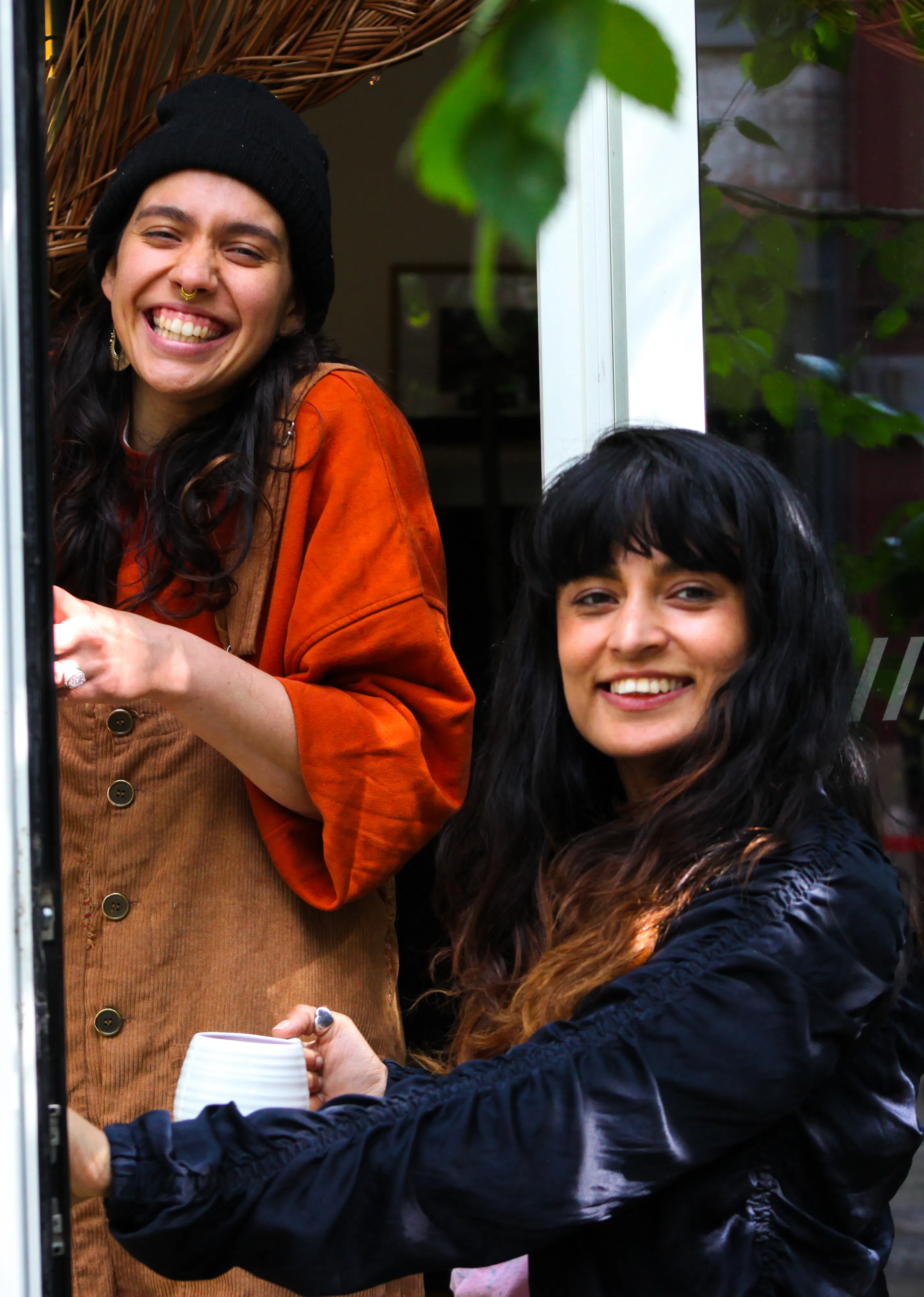 Two people smiling with tea cups in their hands