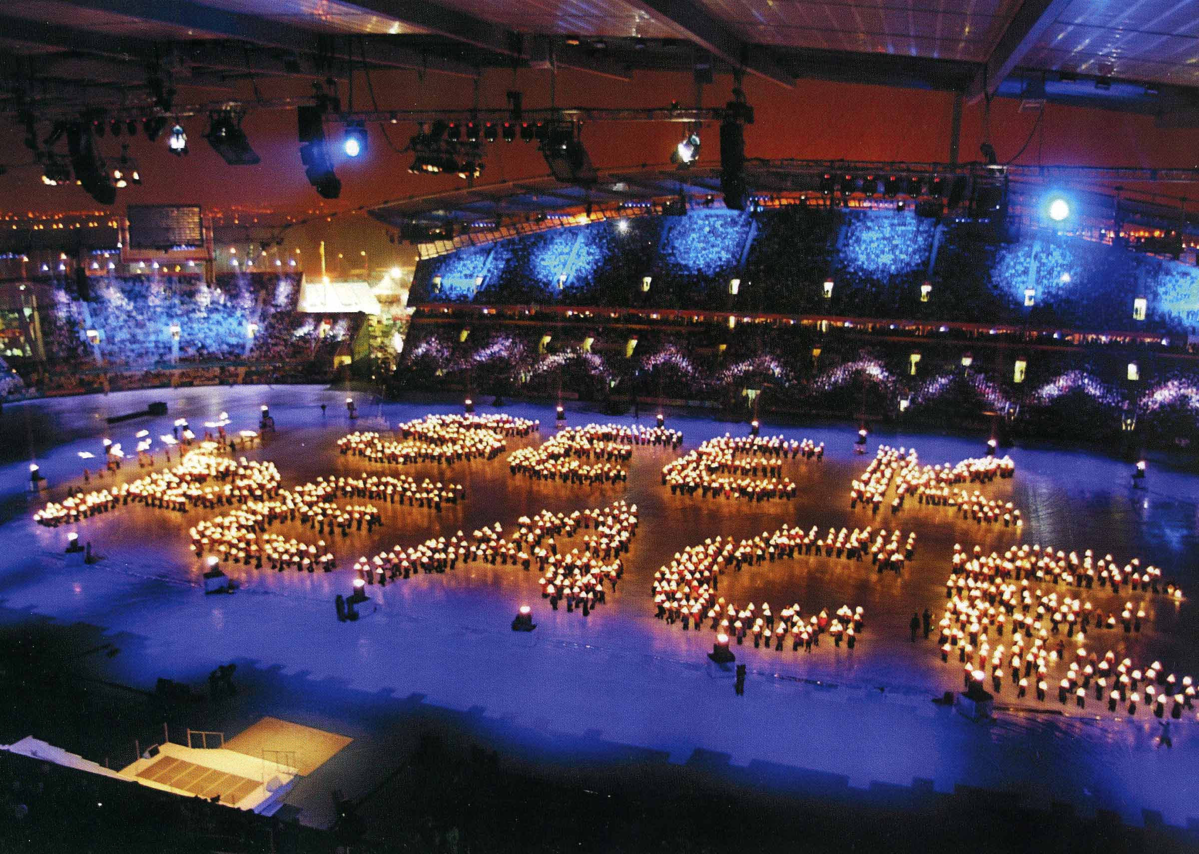 Hundreds of lanterns in the centre of an arena spelling out the words 'Seek Peace'