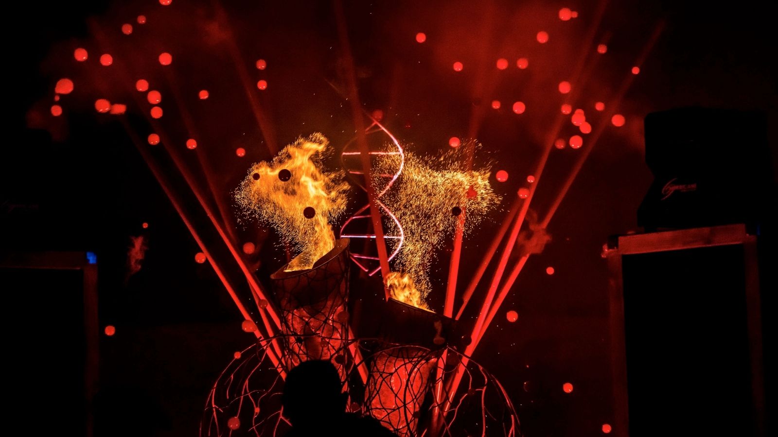 The valves of a mechanical heart spewing out sparks in a red-lit room