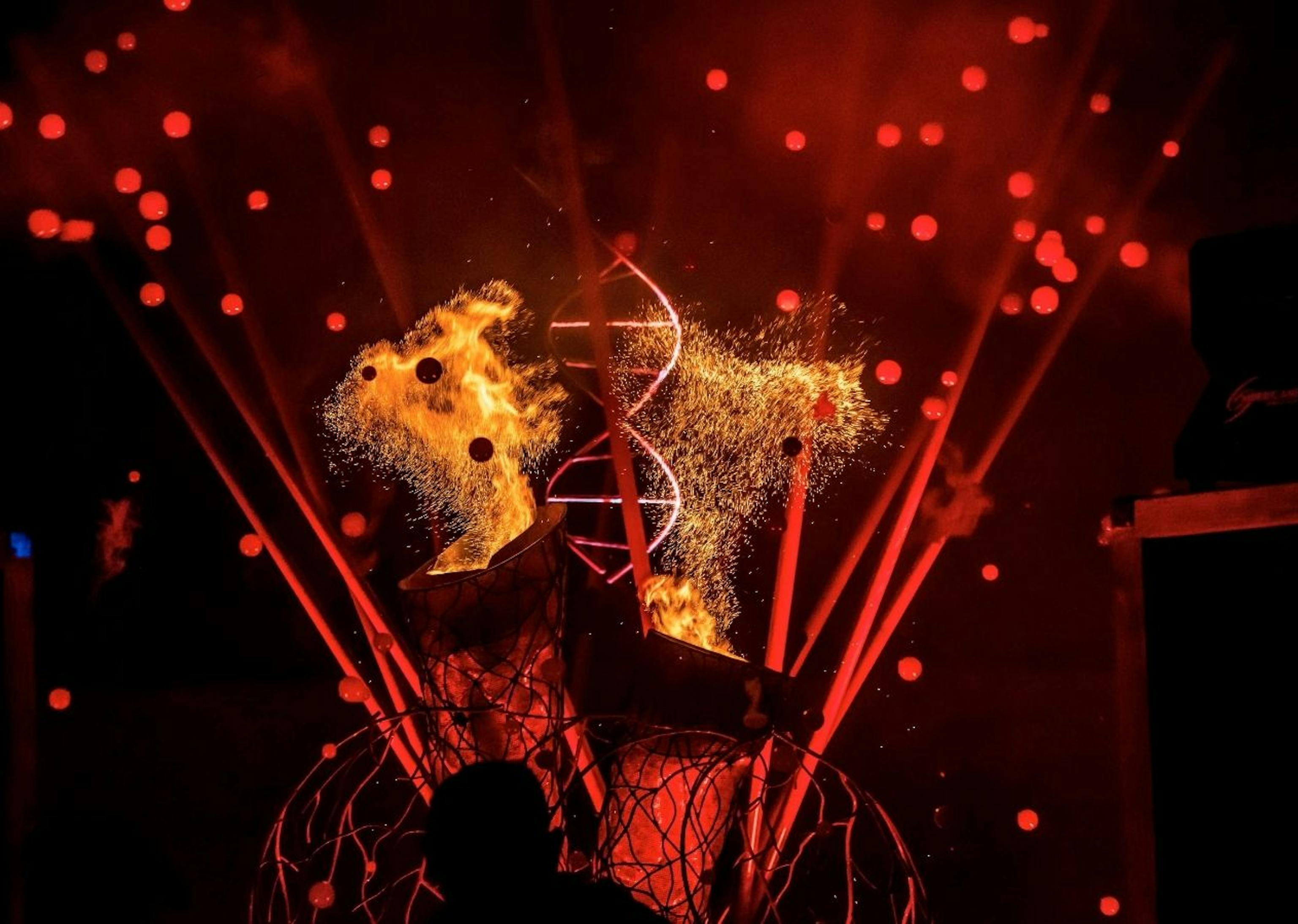 The valves of a mechanical heart spewing out sparks in a red-lit room