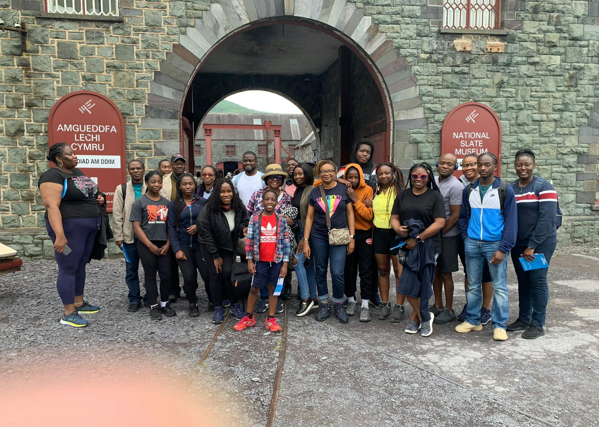 A group of people posing for a picture in front of the National Slate Museum