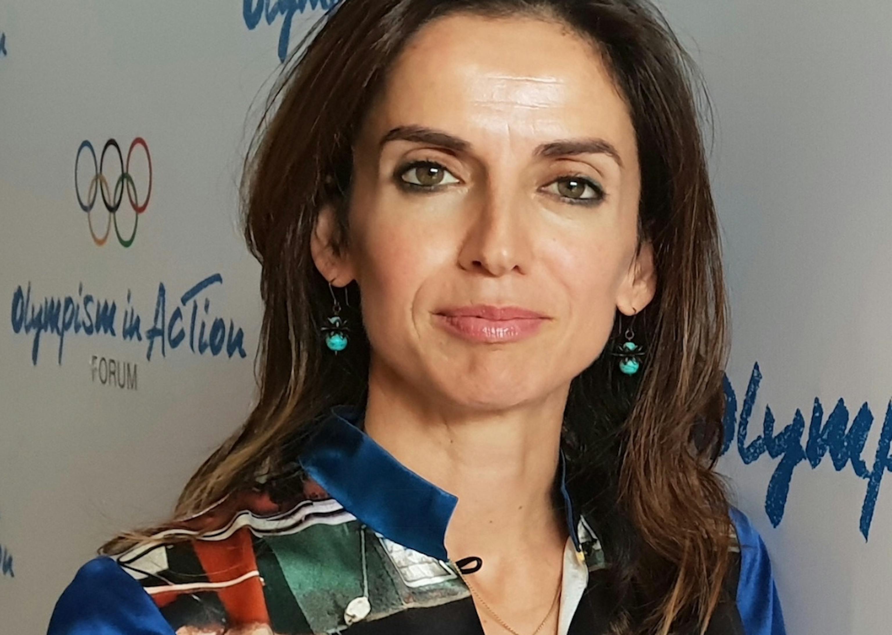 A woman with dark brown hair wearing a striped shirt