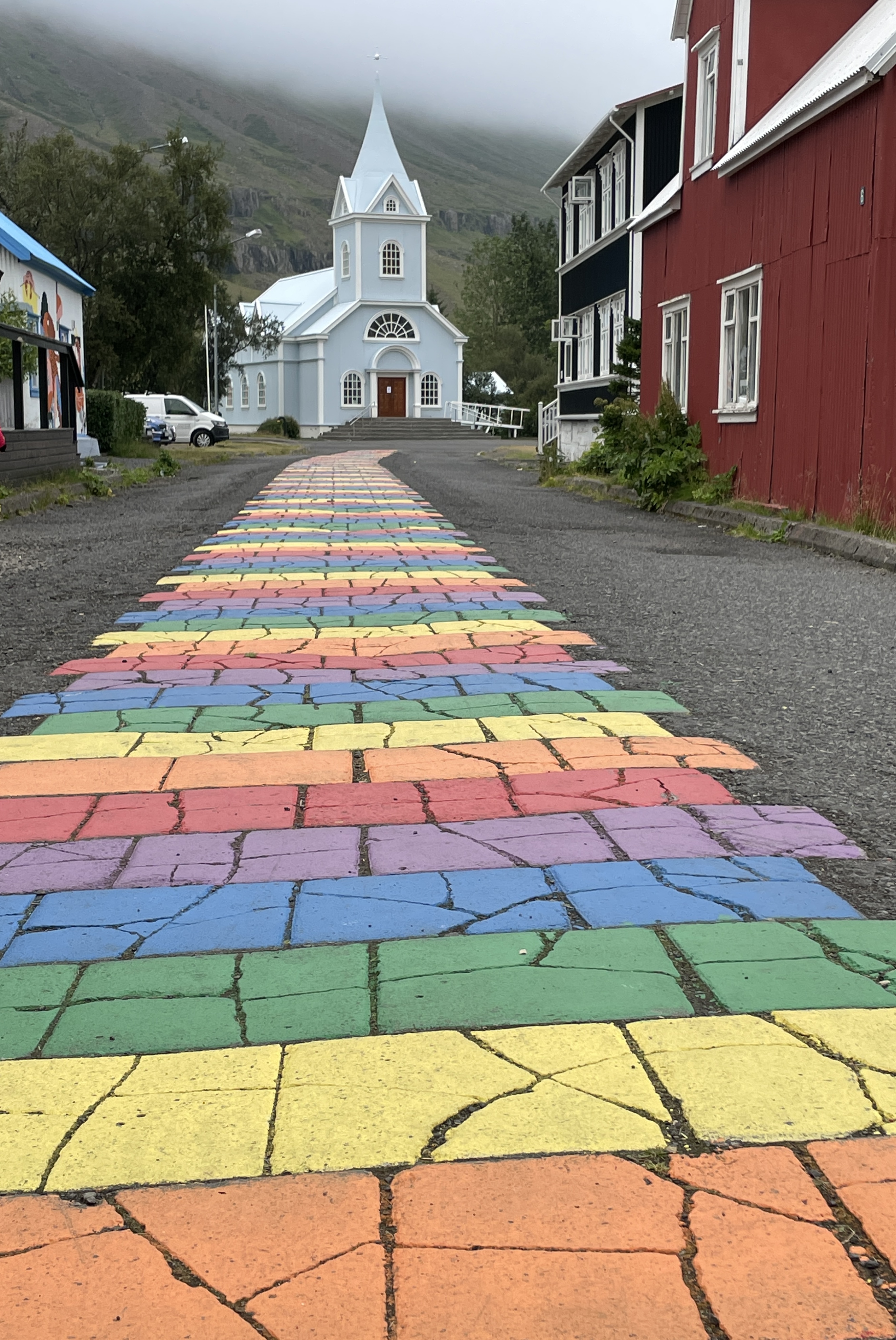 Rainbow painted walkway that leads to a white church