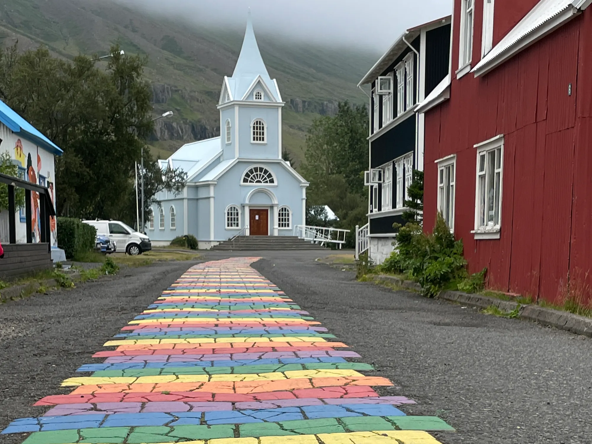 Rainbow painted walkway that leads to a white church