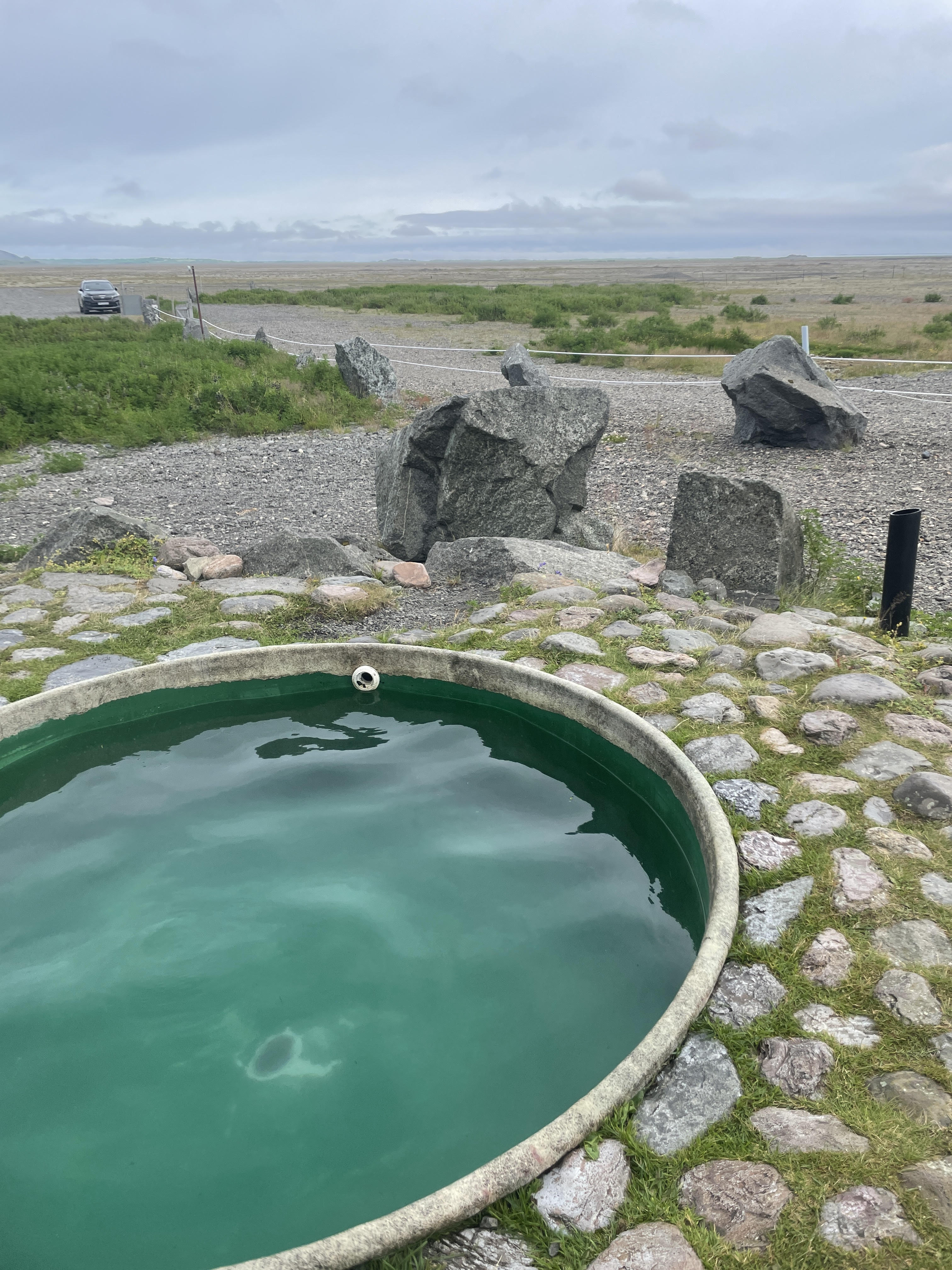 outdoor hottub surrounded by rocks and grass