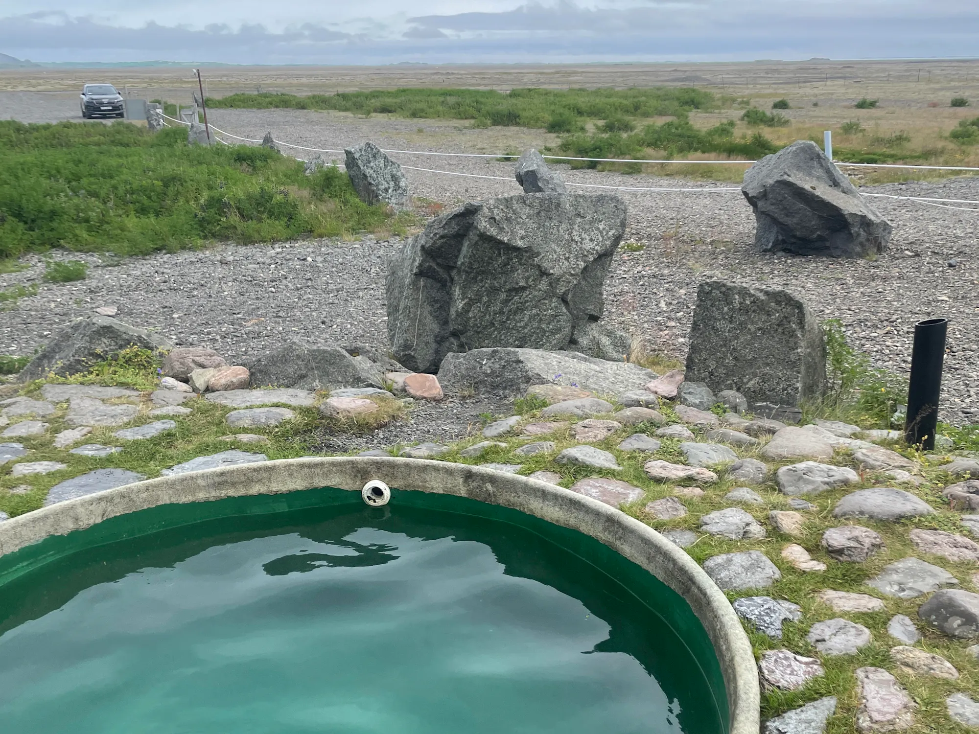 outdoor hottub surrounded by rocks and grass