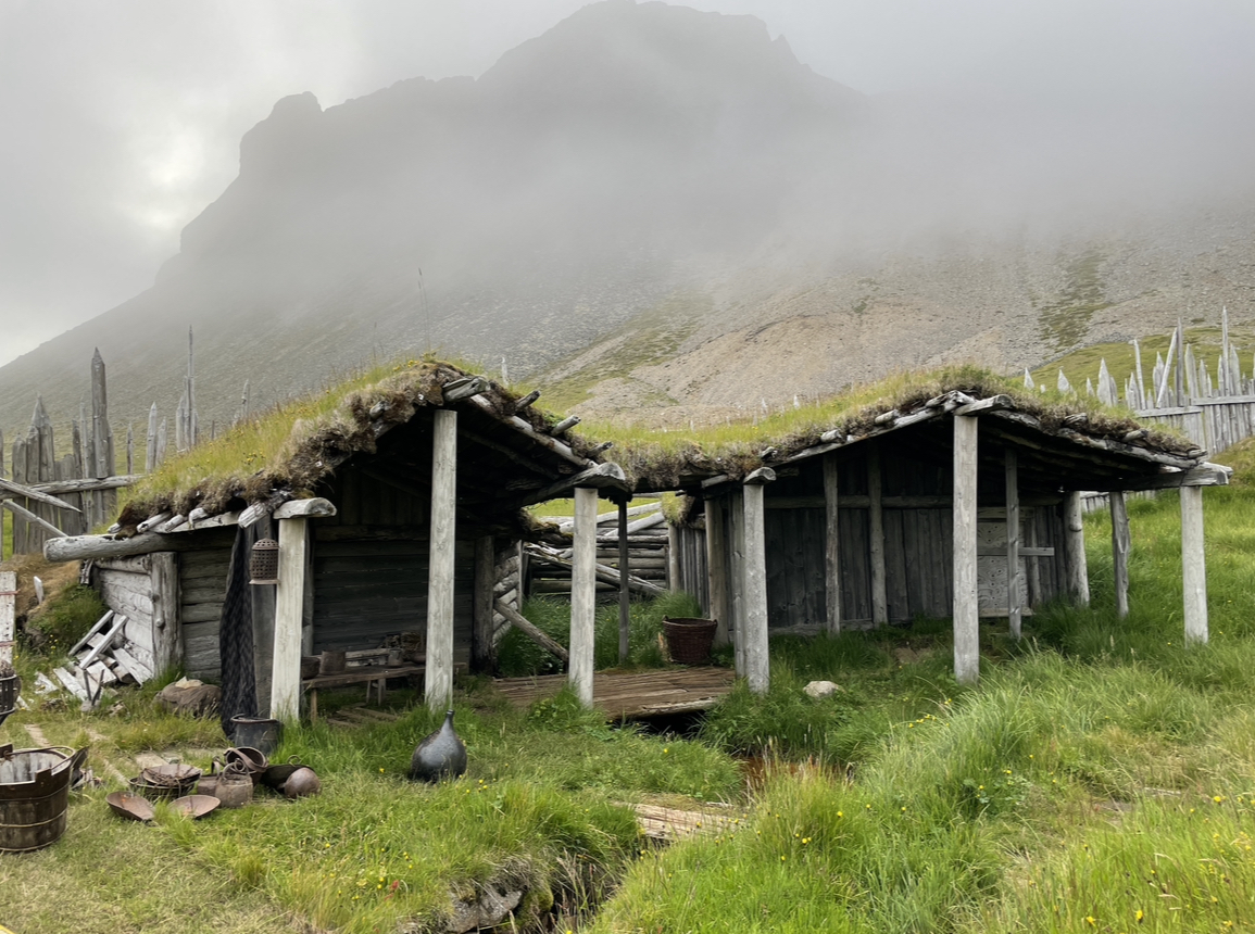 Old viking village at the base of a mountain with mist in the background
