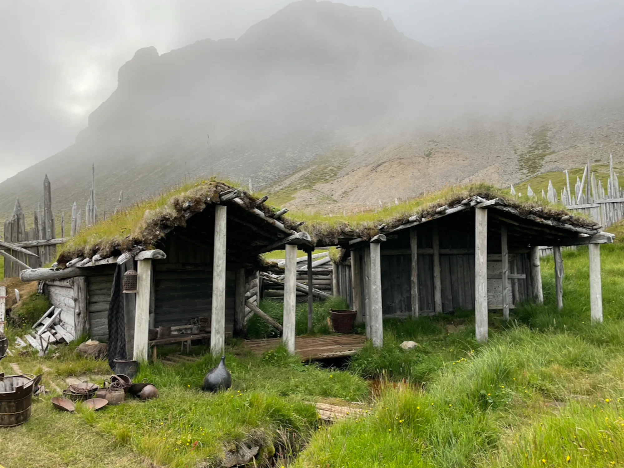 Old viking village at the base of a mountain with mist in the background