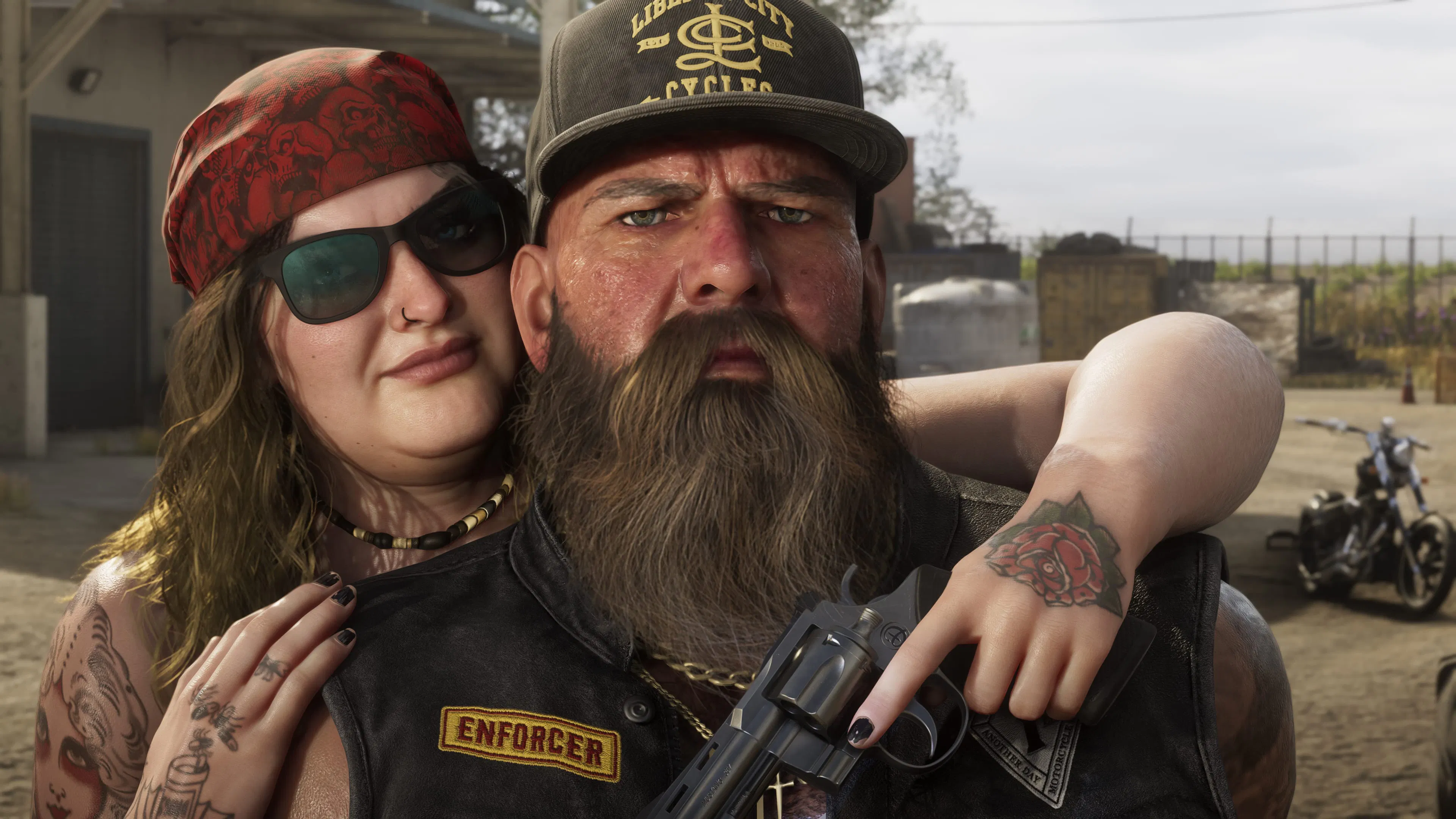A bearded biker in an Enforcer vest, revolver in hand, and a woman in a bandana.