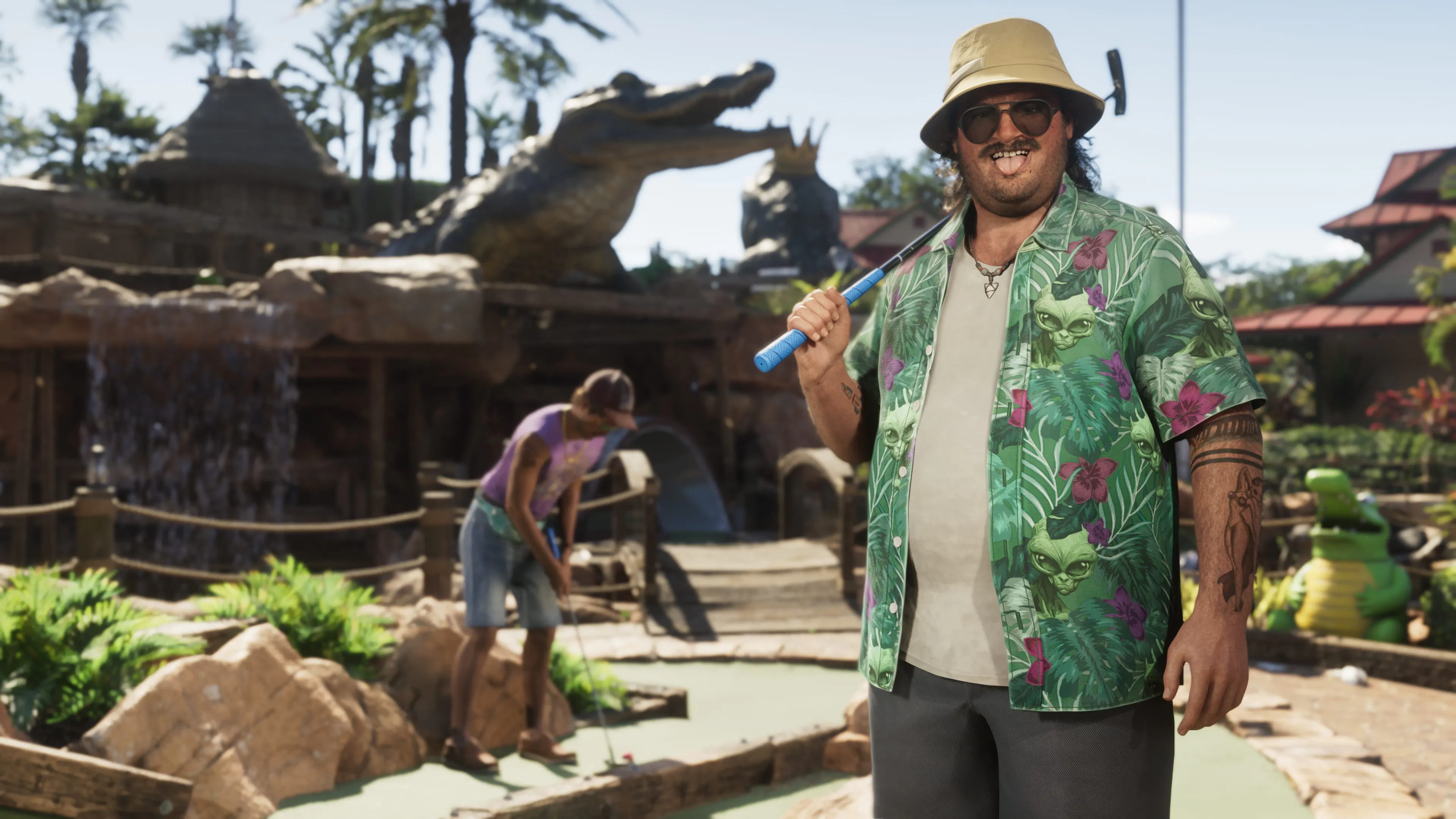 Cal Hampton, putter on his shoulder, at a mini golf course with a giant alligator.