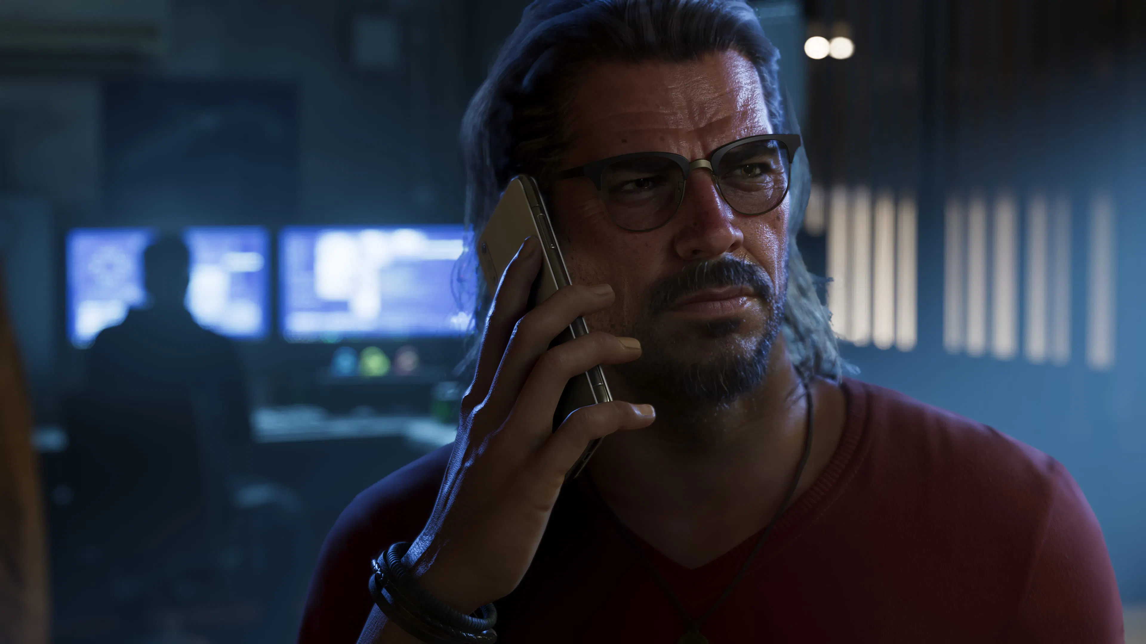 Raul Bautista on the phone, in glasses, in front of computer screens.