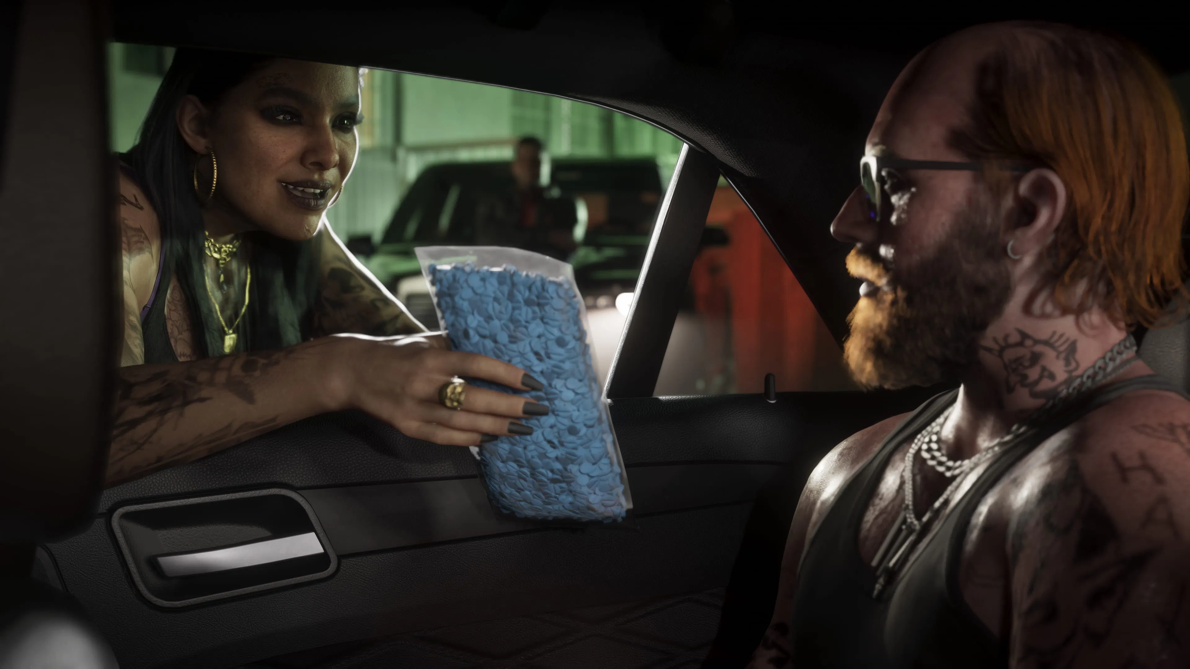 A woman hands a bag of blue pills to a bearded man in a car.