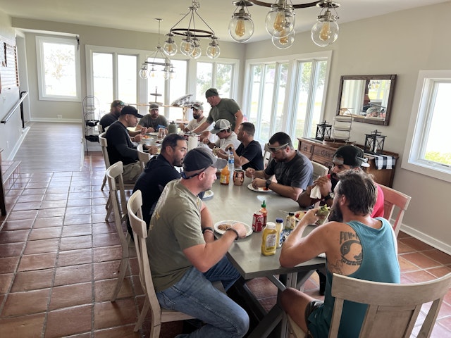 In the dining room of Patriot Point's main house, 12 Marines from 1st Platoon CLR 15, sit around the dining room table, eat, and reminisce. 