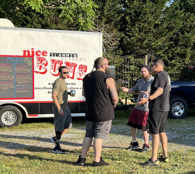 Outside, in front of the Nice Buns Slammin Sliders food truck, soldiers from 1-172 catch up while waiting for food.