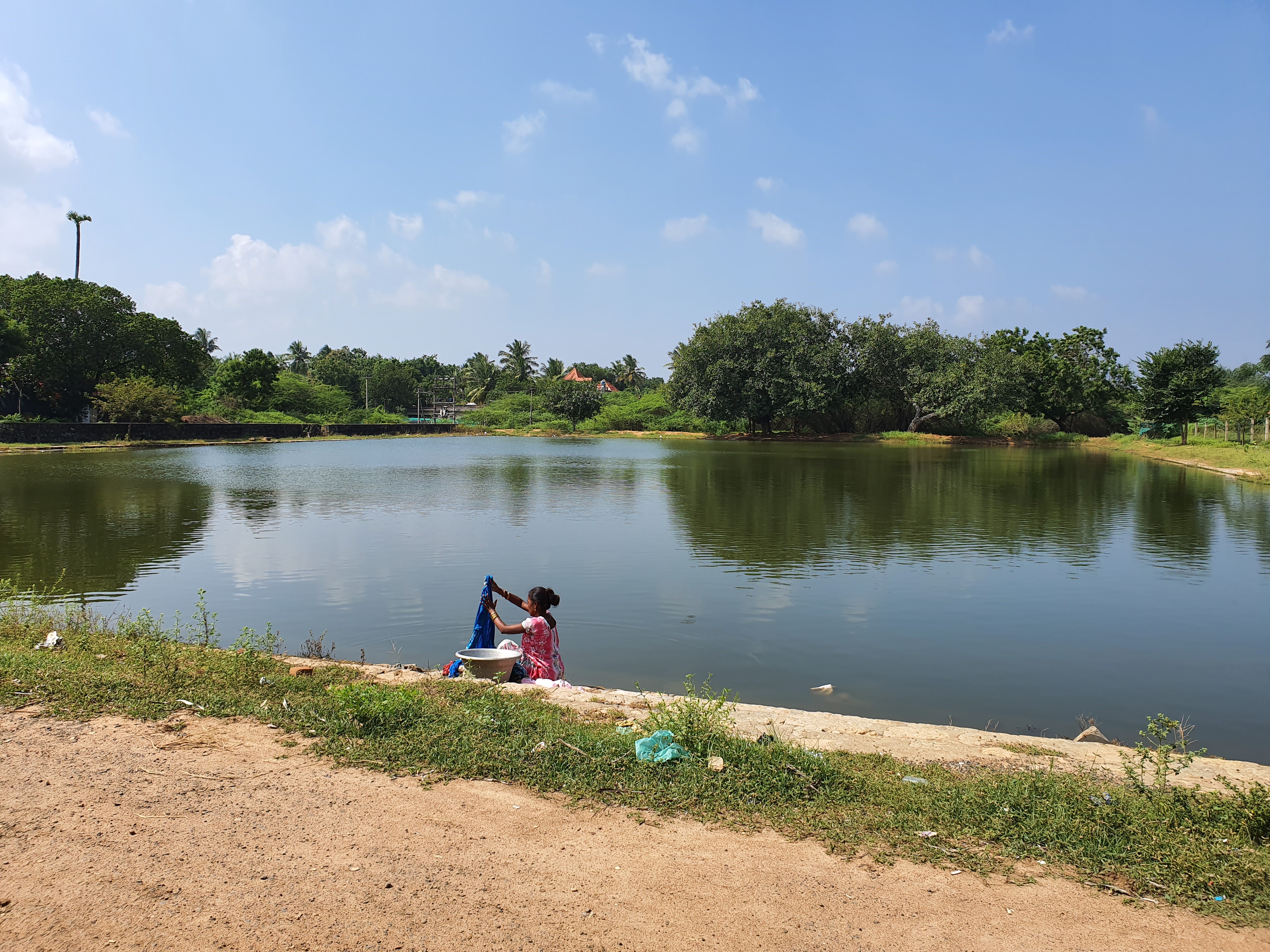 Woman washing clothes in a lake.