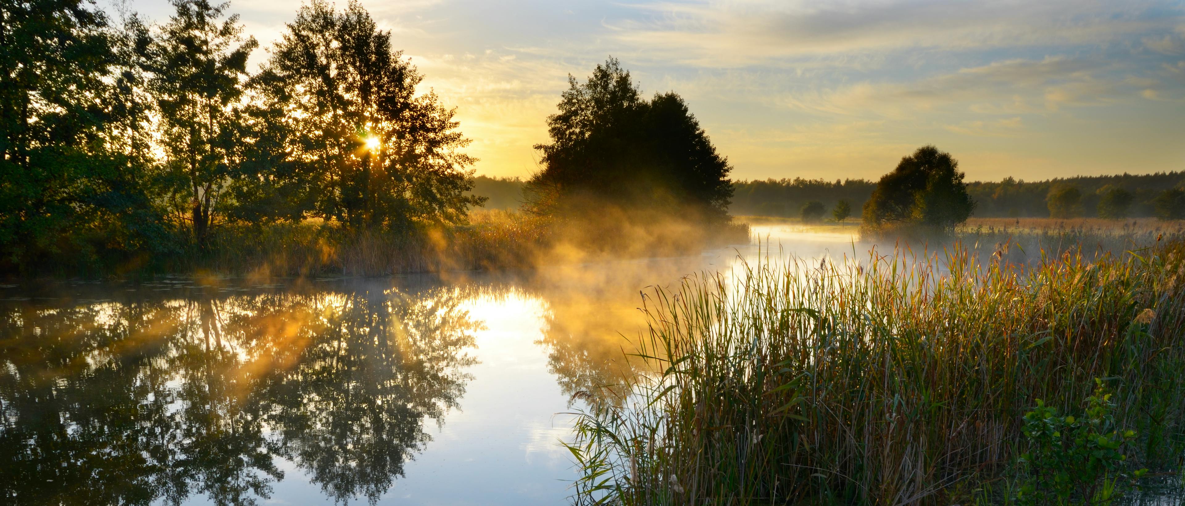 Sunset over a water retention pond feature, light glistening off the surface