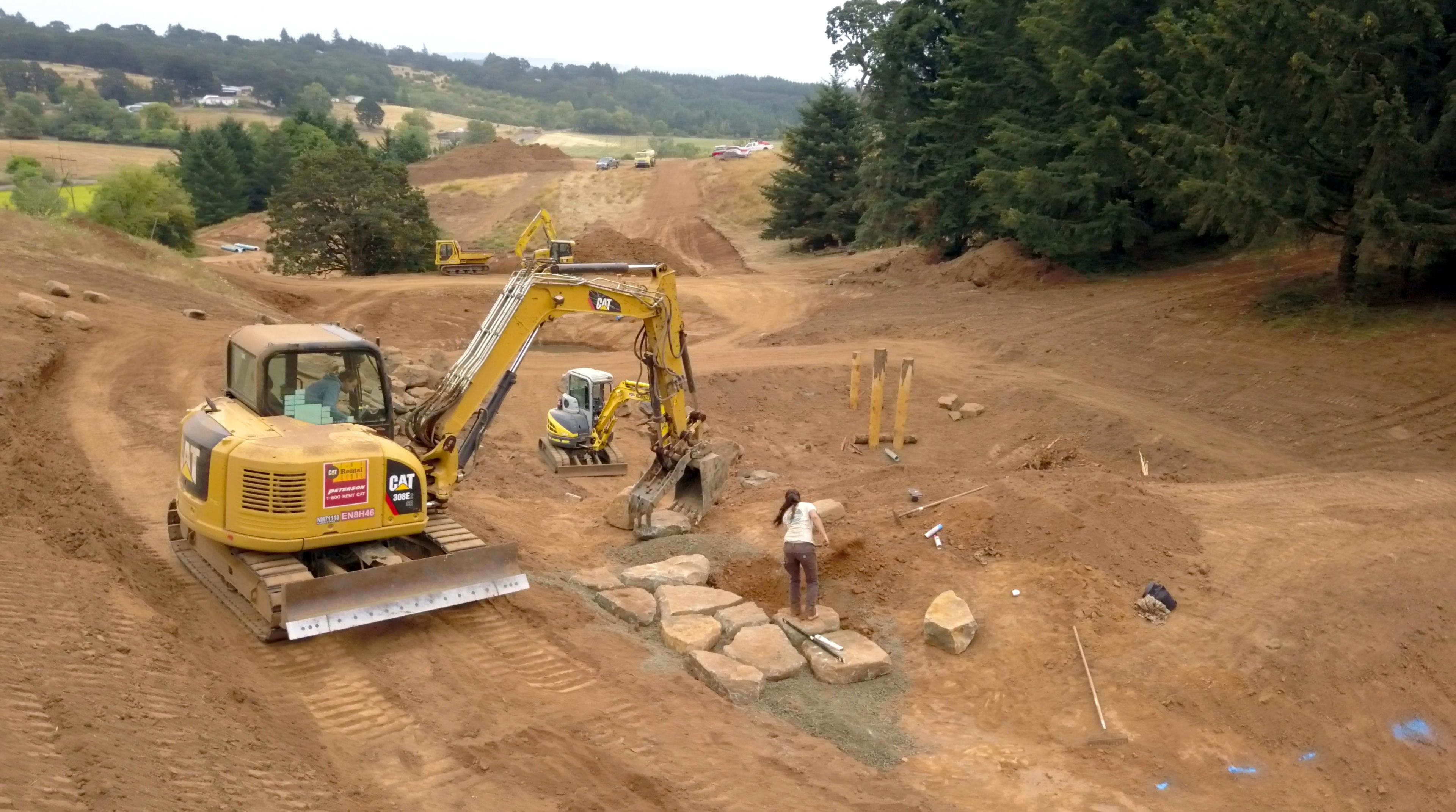 Large machines completing earthworks during a water restoration project