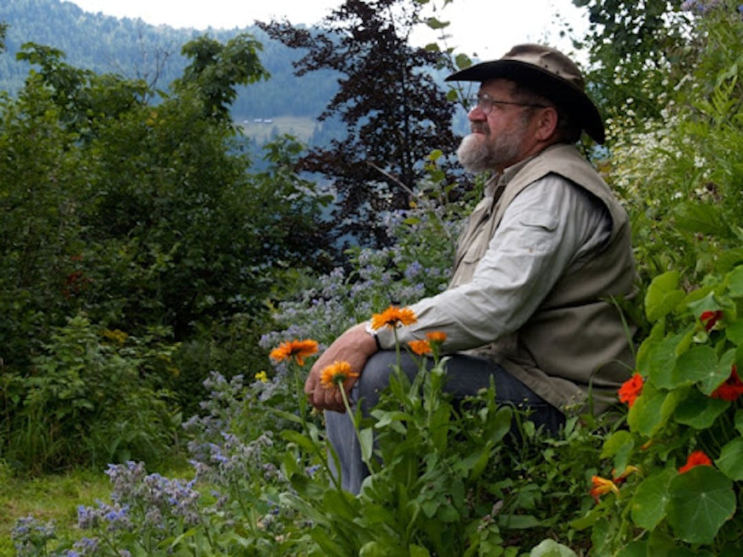 Sepp Holzer at the Krameterhof in Austria, surrounded by abundant edible plants and looking out across the landscape