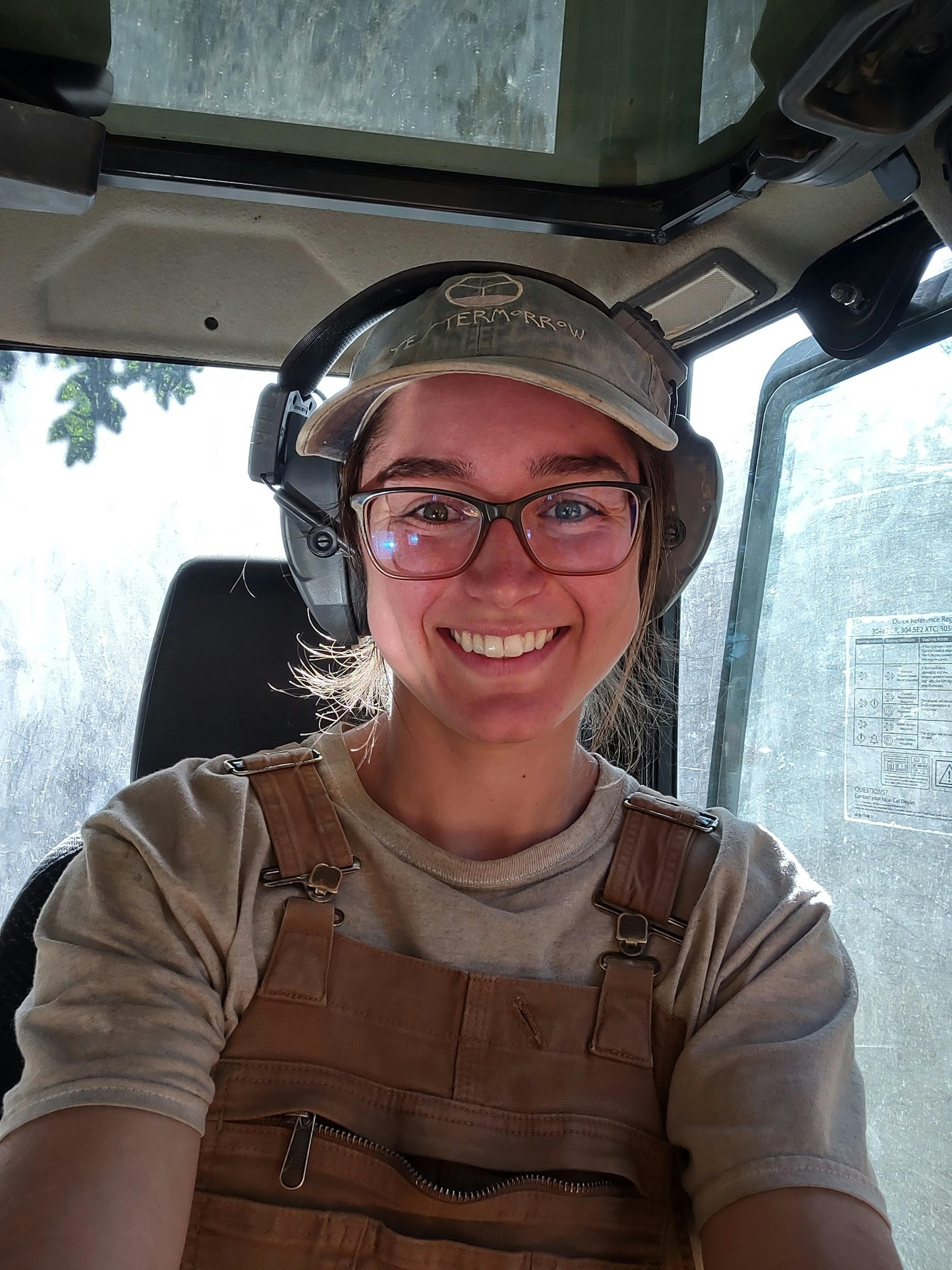 Megan Neary headshot taken while inside an excavator and wearing safety gear