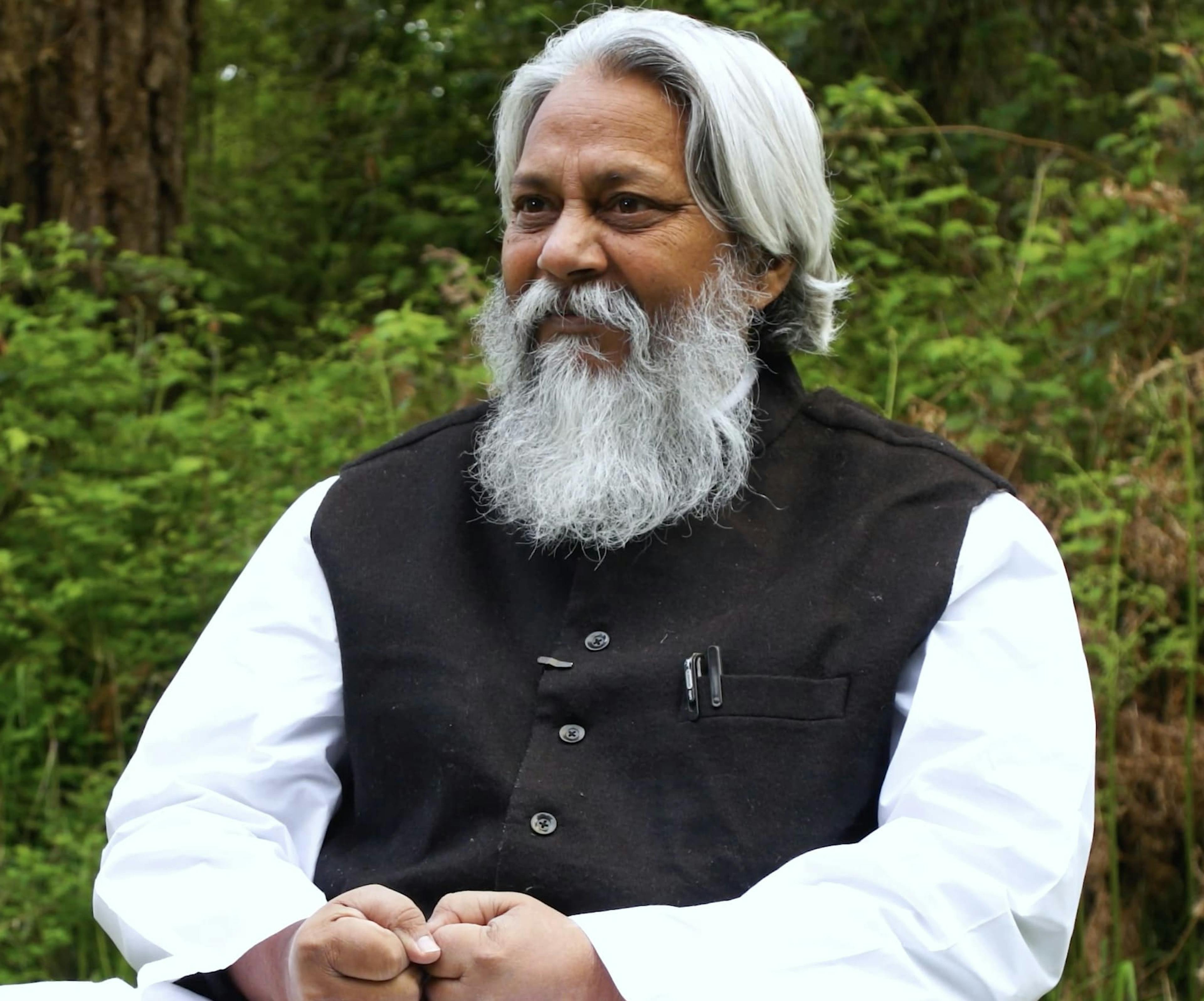 Headshot of Rajendra Singh, the Waterman of India smiling and wearing a red striped cotton shirt