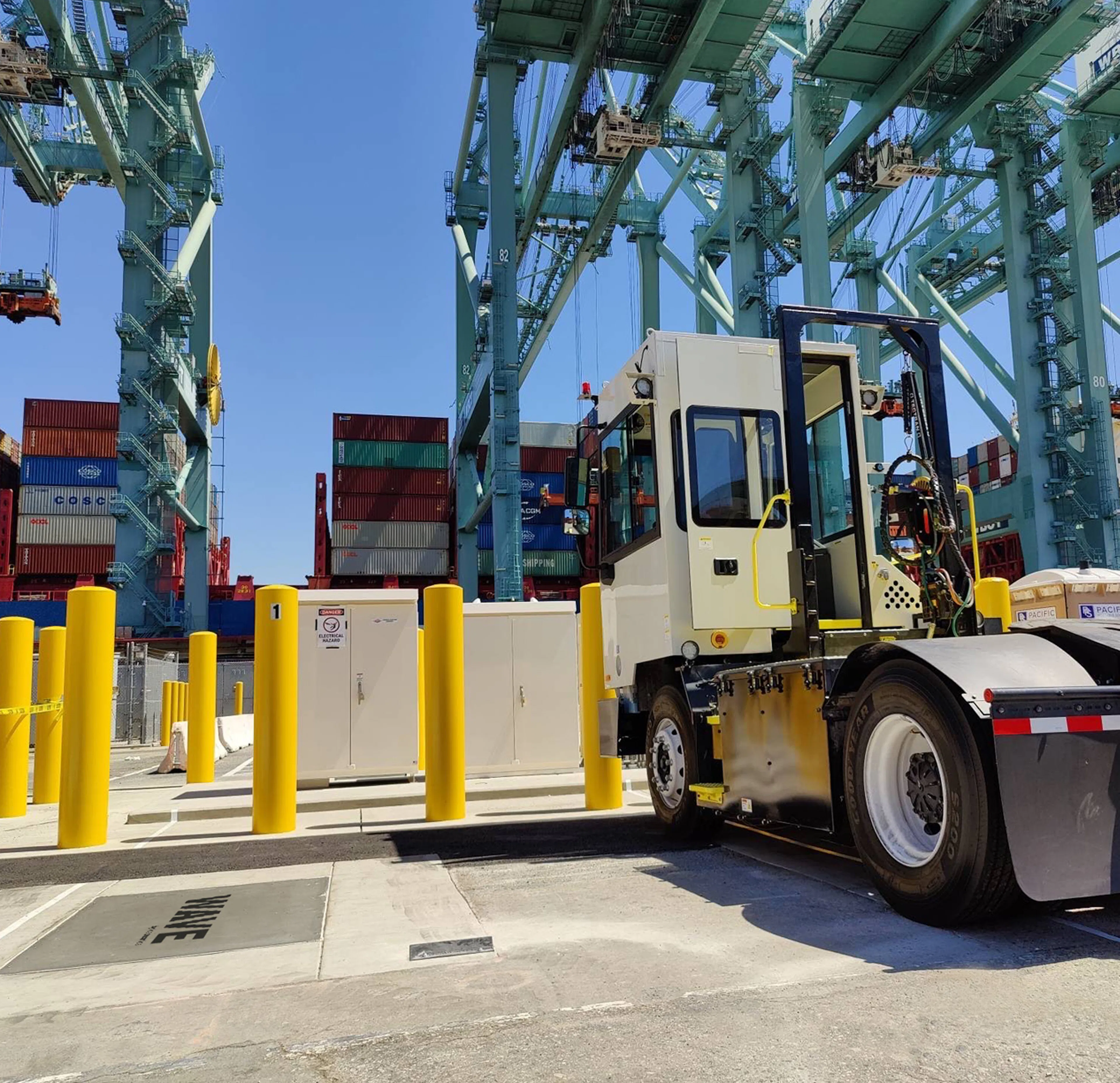 An electric yard tractor charging wirelessly at a port