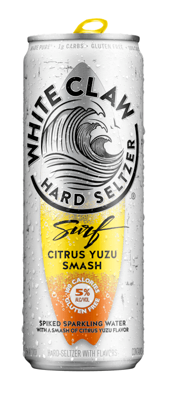 A can of White Claw® Surf Citrus Yuzu sits on rocks in front of the sea.