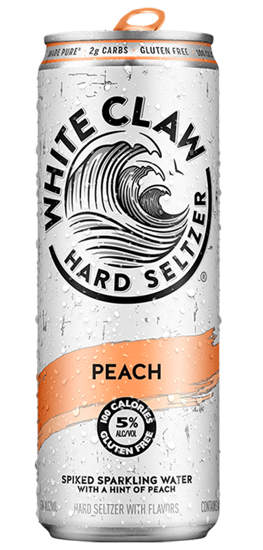 A can of White Claw® Hard Seltzer Peach sits on rocks in front of the sea.